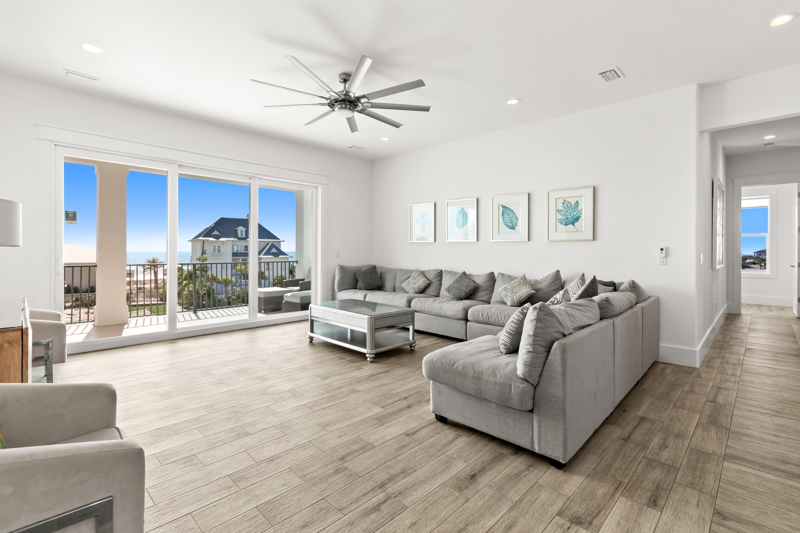 Sink into plush seating and take in glimpses of blue sky and palm trees through your private balcony doors—your coastal escape begins here.