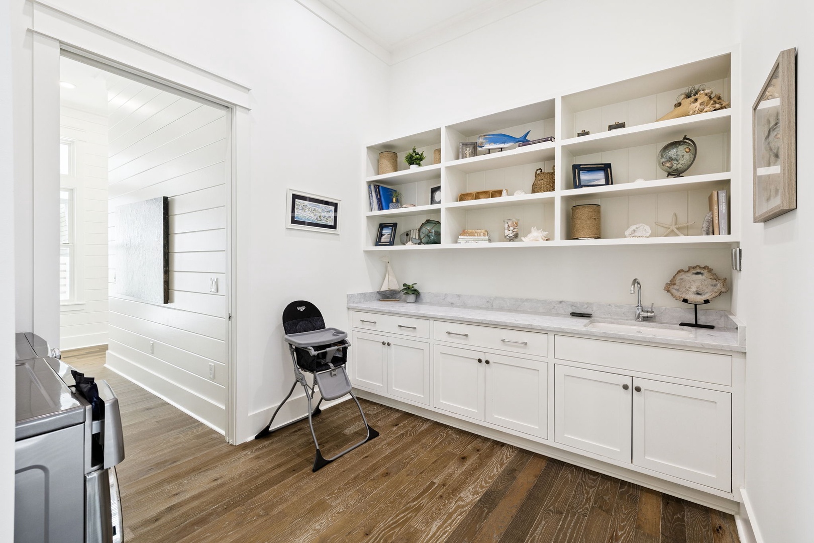 Your spacious butler's pantry features elegant marble counters and custom shelving, perfect for preparing meals and storing your coastal treasures.