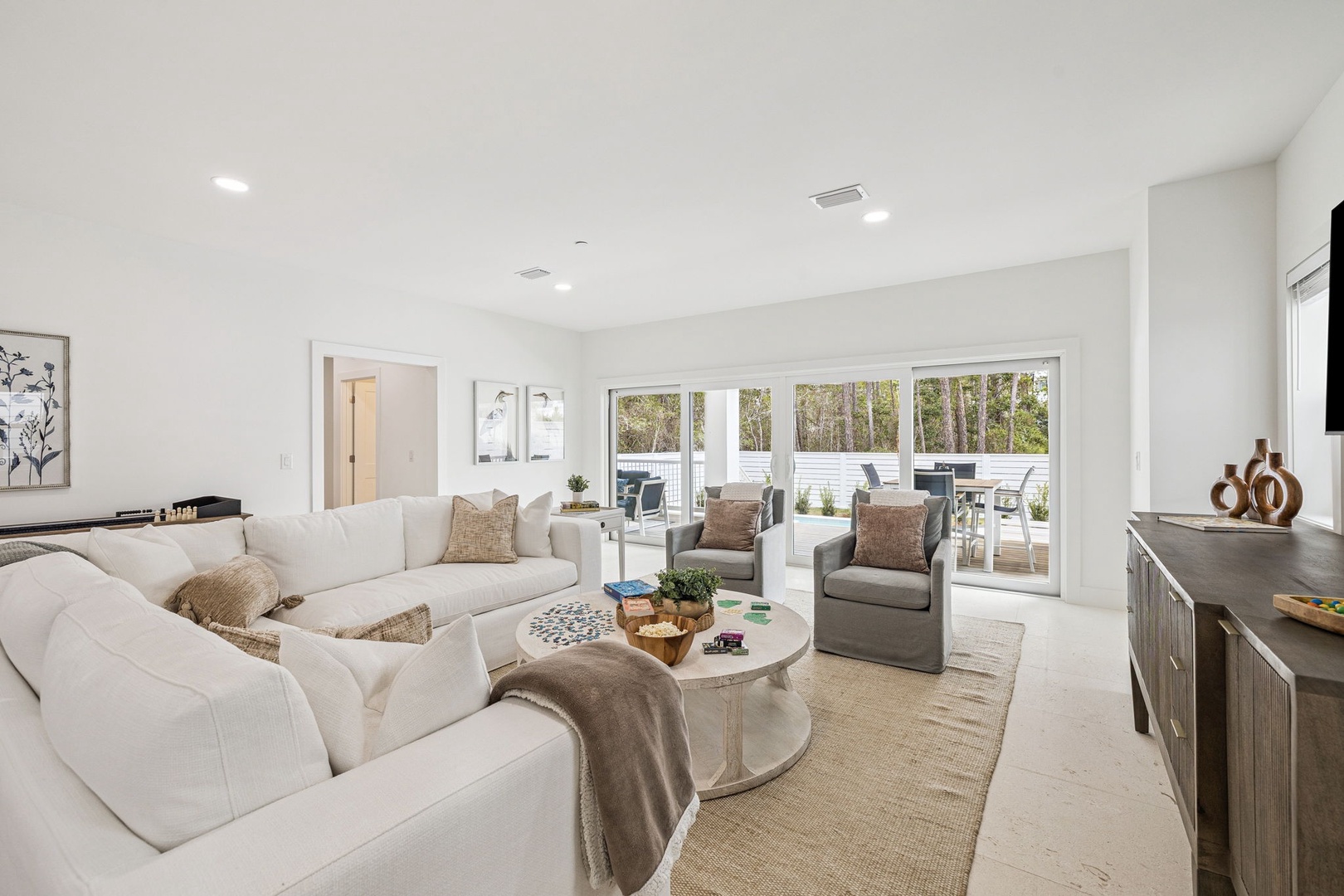 Sink into plush seating and enjoy natural light streaming through floor-to-ceiling windows in your elegant living space.