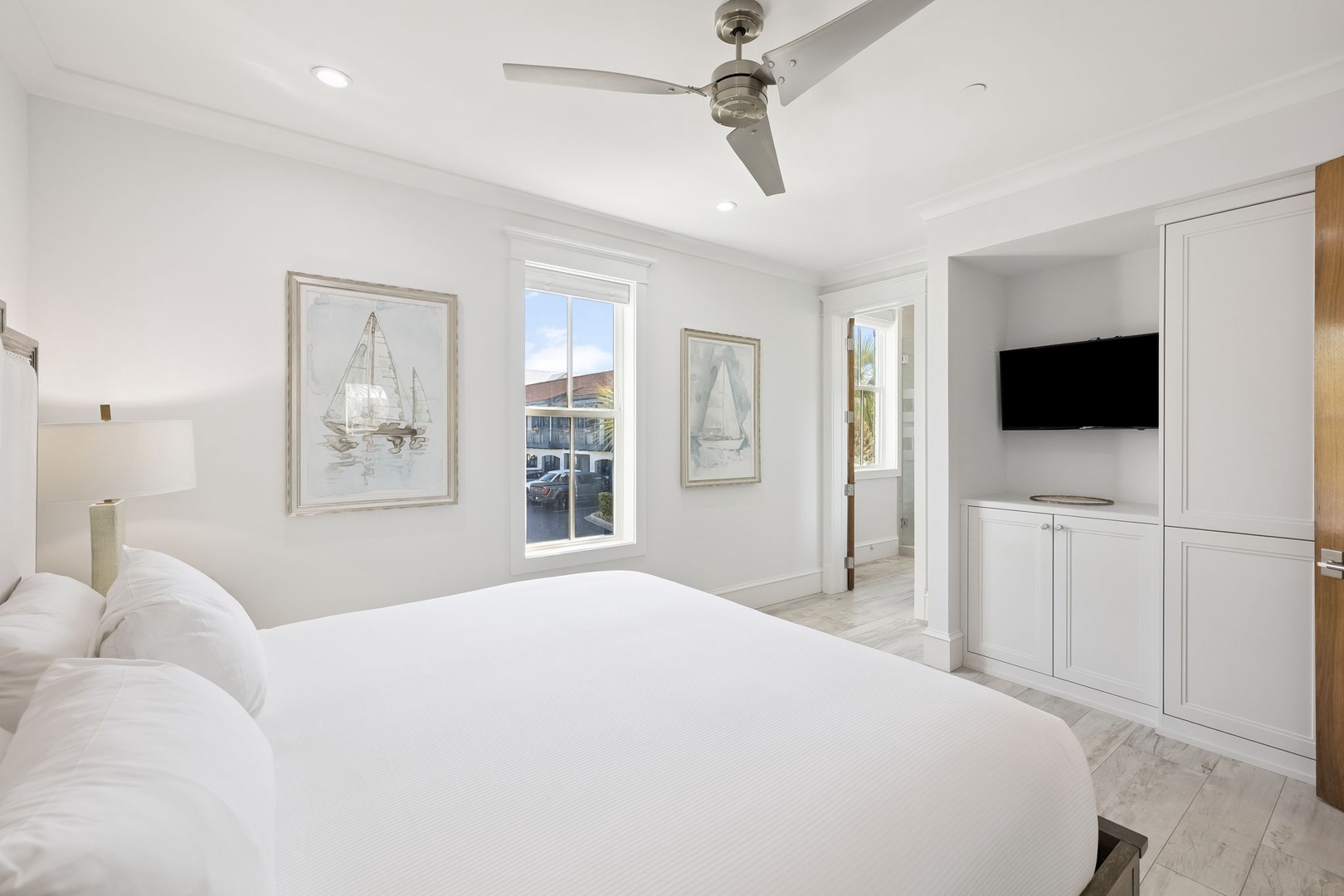 Your bright bedroom features coastal charm with nautical artwork, a ceiling fan for comfort, and built-in storage for all your belongings.