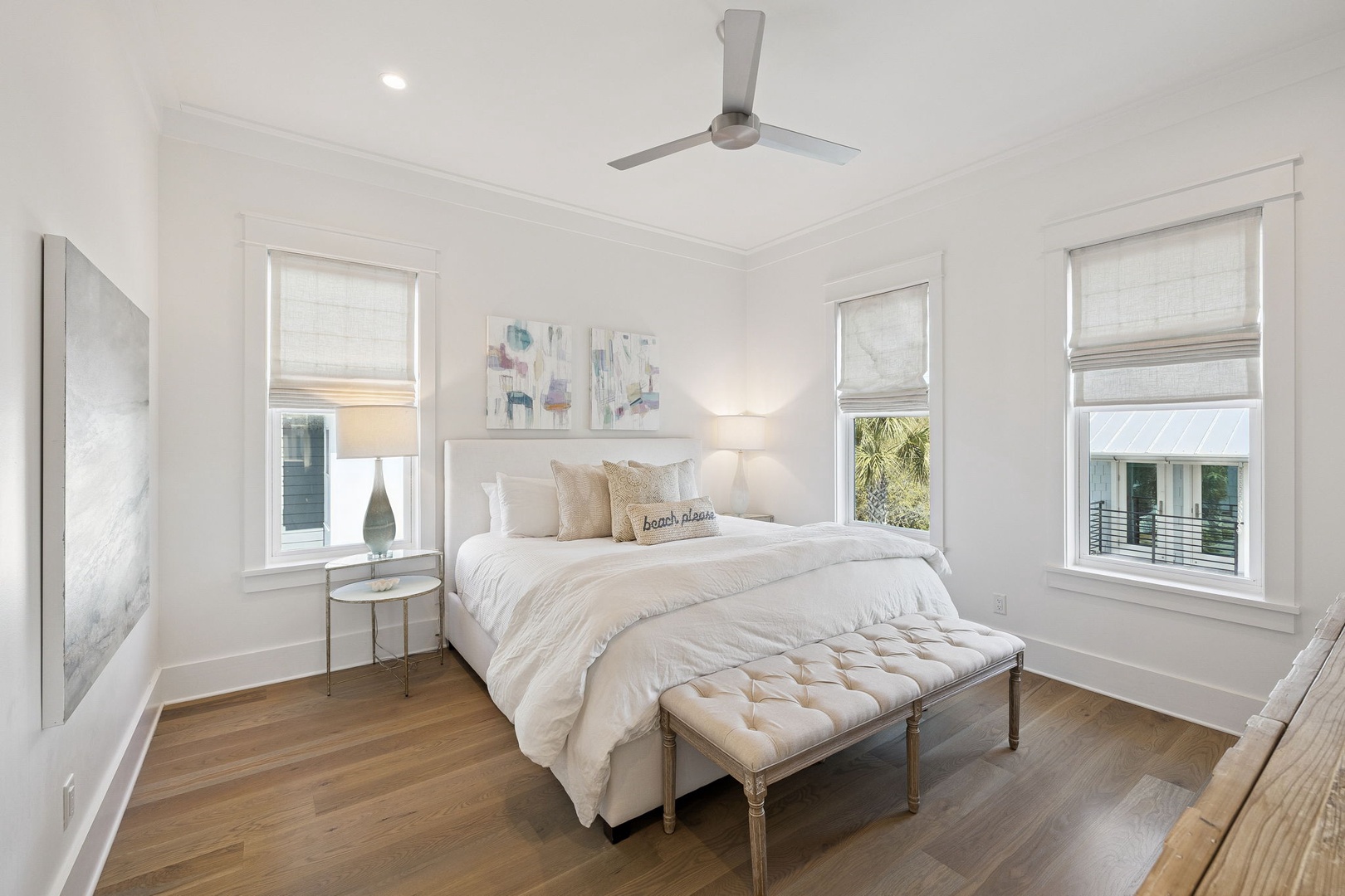 Drift off in your serene bedroom sanctuary with coastal artwork, plush bedding, and ocean breezes from multiple windows.