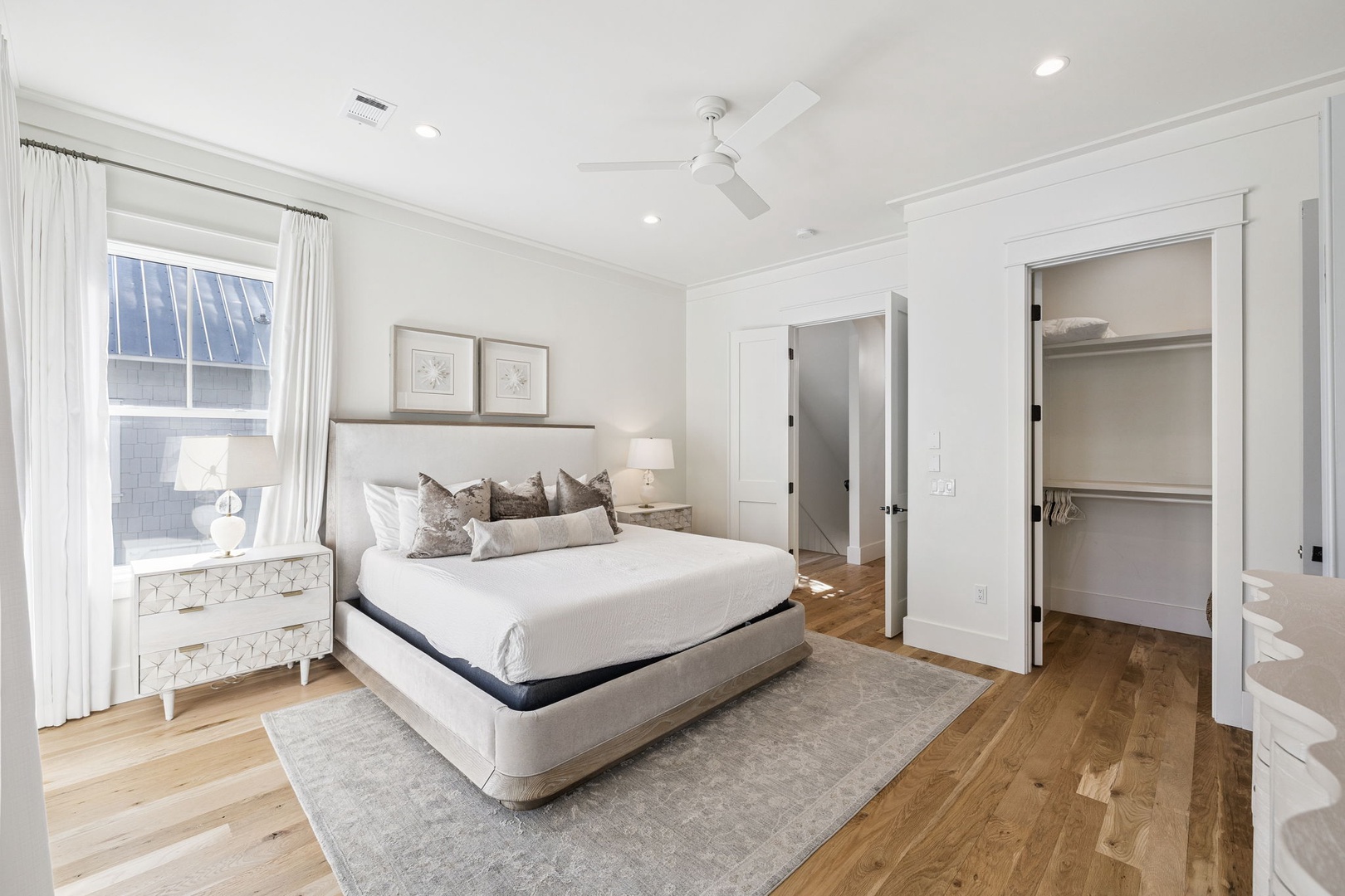 Sink into crisp white linens and designer pillows in your serene bedroom retreat, complete with warm hardwood floors and a spacious walk-in closet.