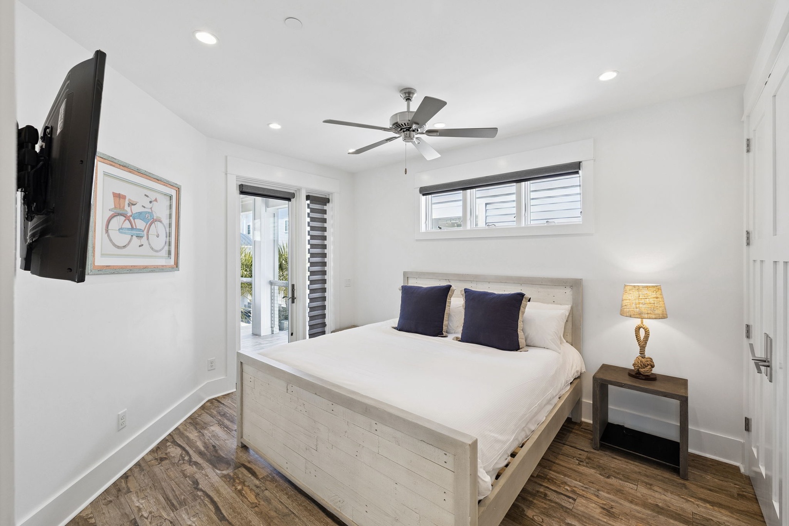 Unwind in your bright bedroom with crisp linens, a cozy reading lamp, and gentle ceiling fan for peaceful nights.