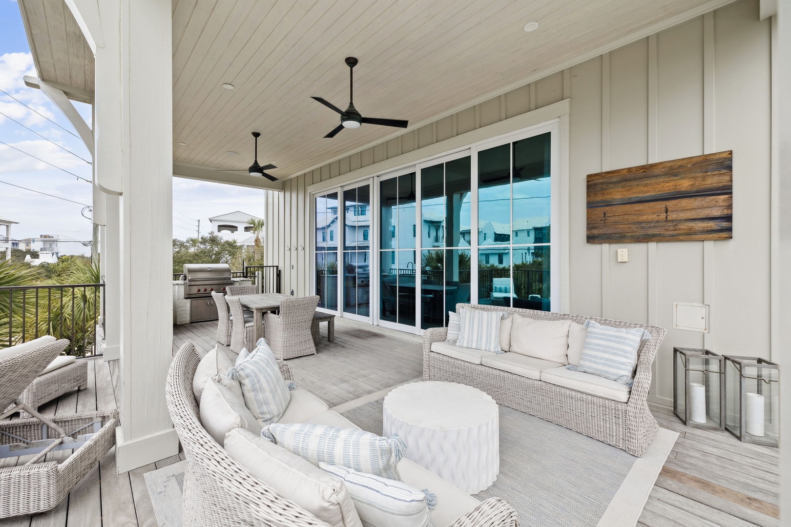 Relax in your covered outdoor living space with comfortable wicker seating, ceiling fans, and grilling area—perfect for entertaining.