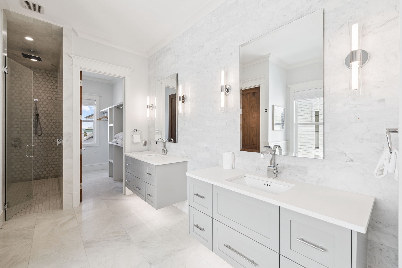 Indulge in your spa-like ensuite with dual vanities, marble finishes, and a stunning walk-in shower featuring elegant hexagon tiles.