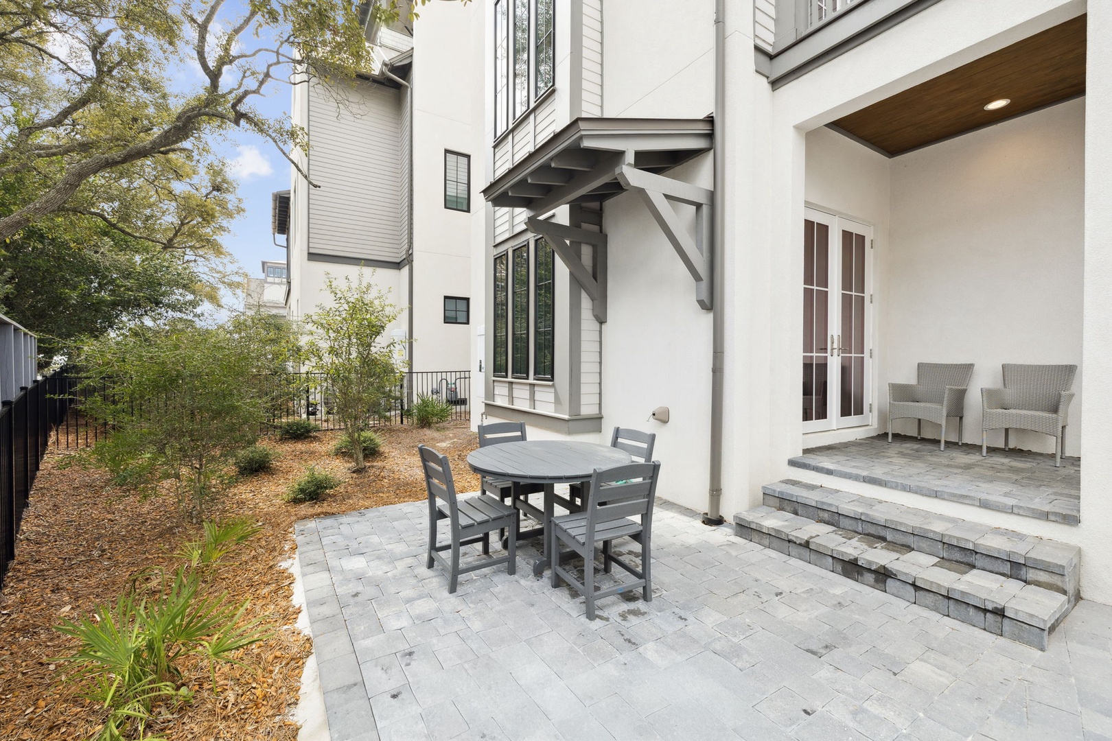 Relax in your private stone patio with dining table and lounge chairs, surrounded by landscaped gardens for peaceful outdoor moments.
