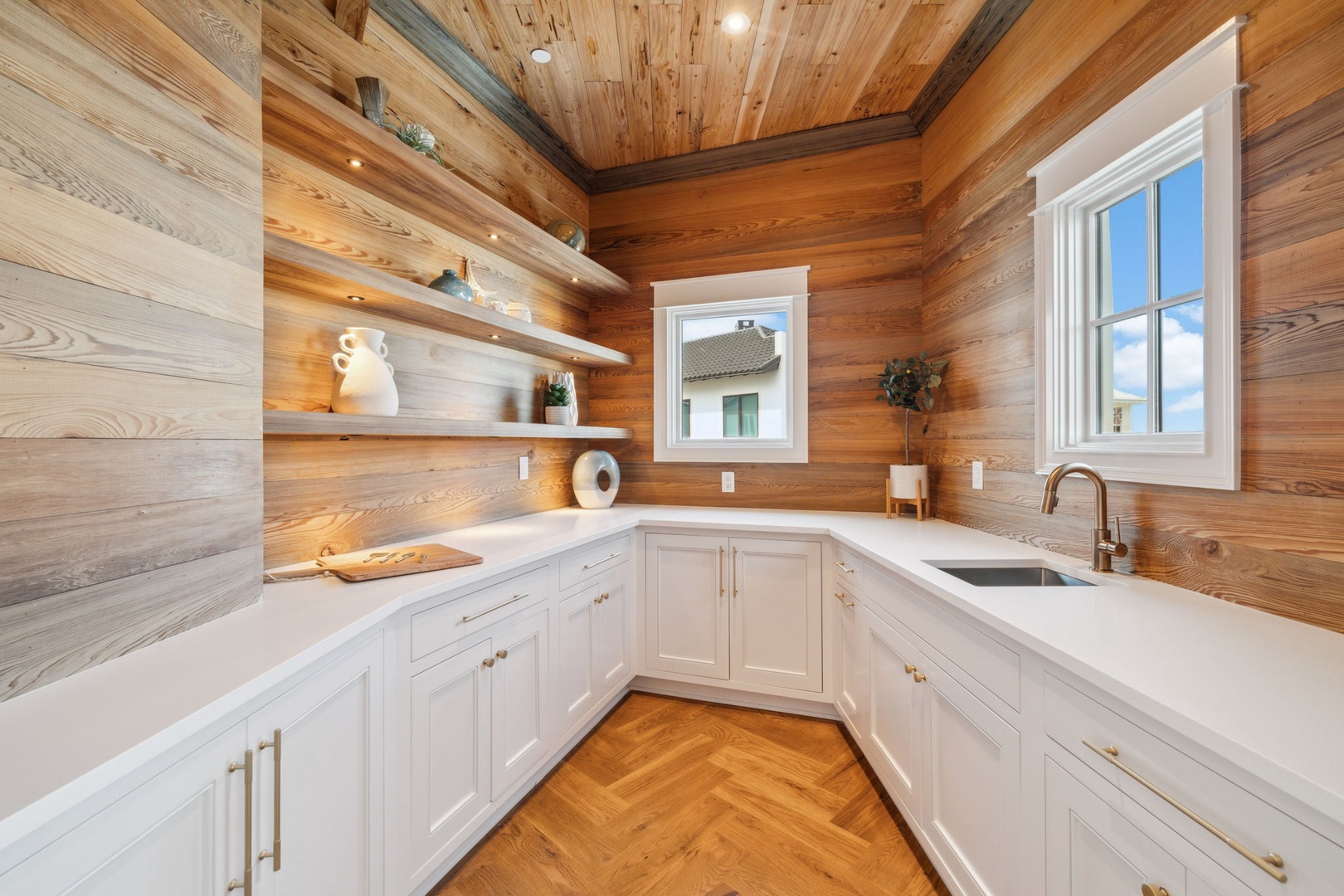 Warm wood tones surround your fully equipped kitchen, where bright natural light and sleek white counters invite you to prepare meals in style and comfort.