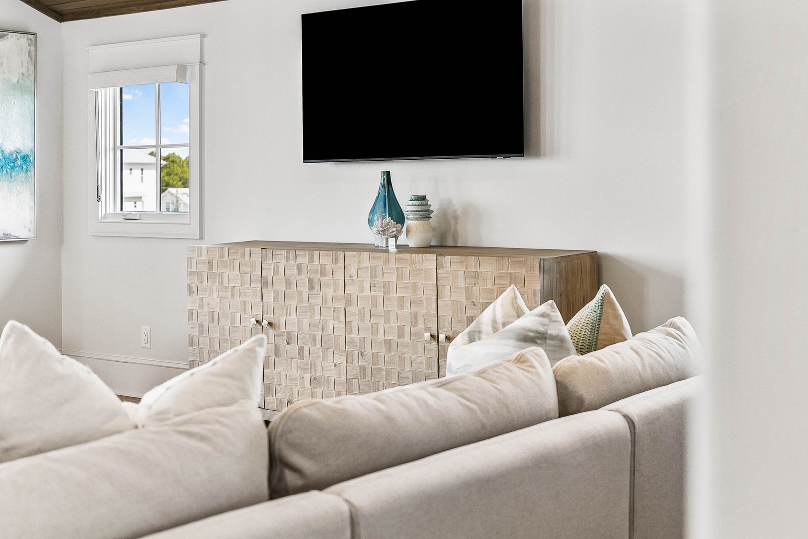 Sink into plush seating in your bright coastal living room, where natural light streams in and your favorite shows await on the wall-mounted TV.