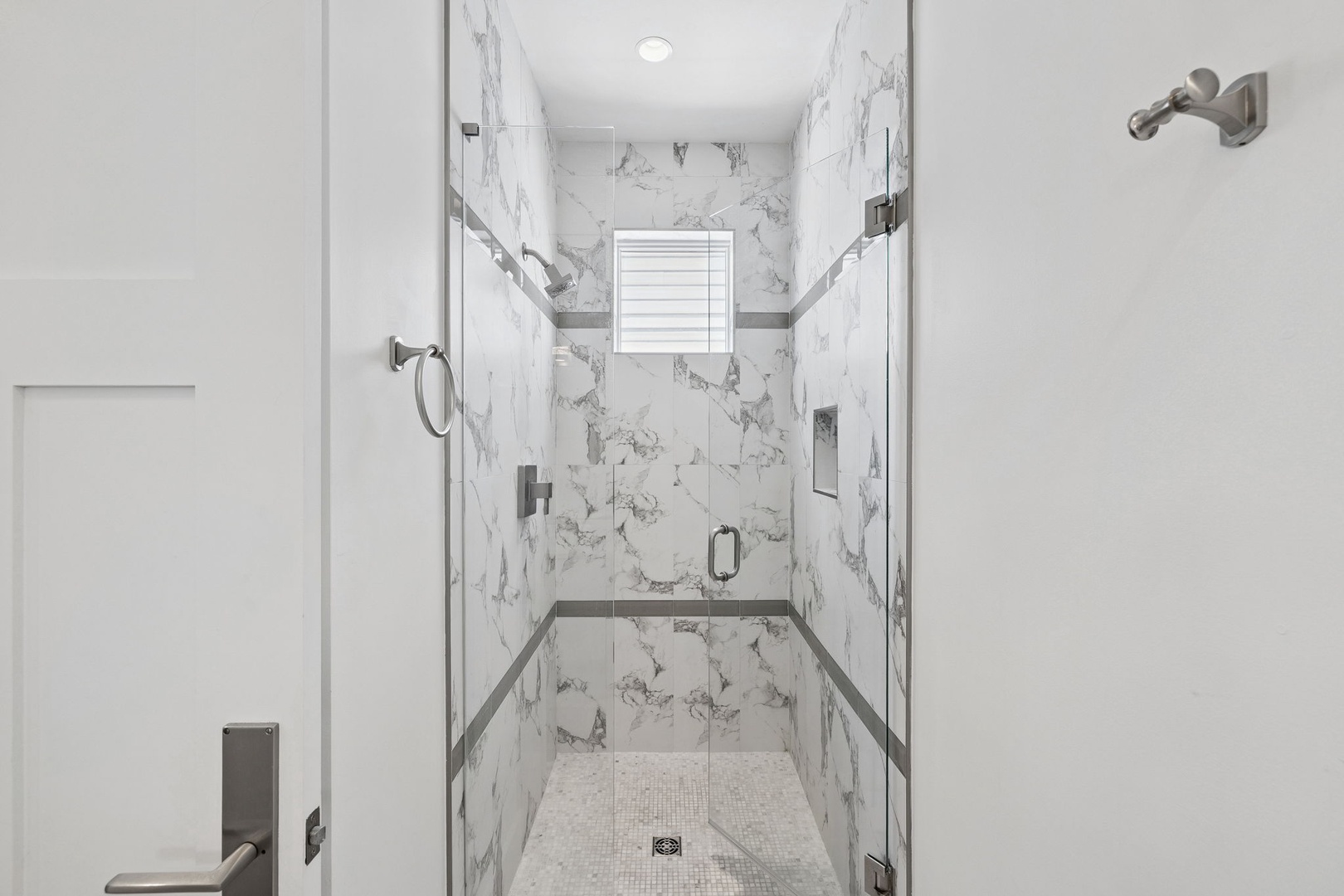Step into your luxurious marble shower sanctuary, where elegant veined walls create a spa-like retreat for your daily refresh.
