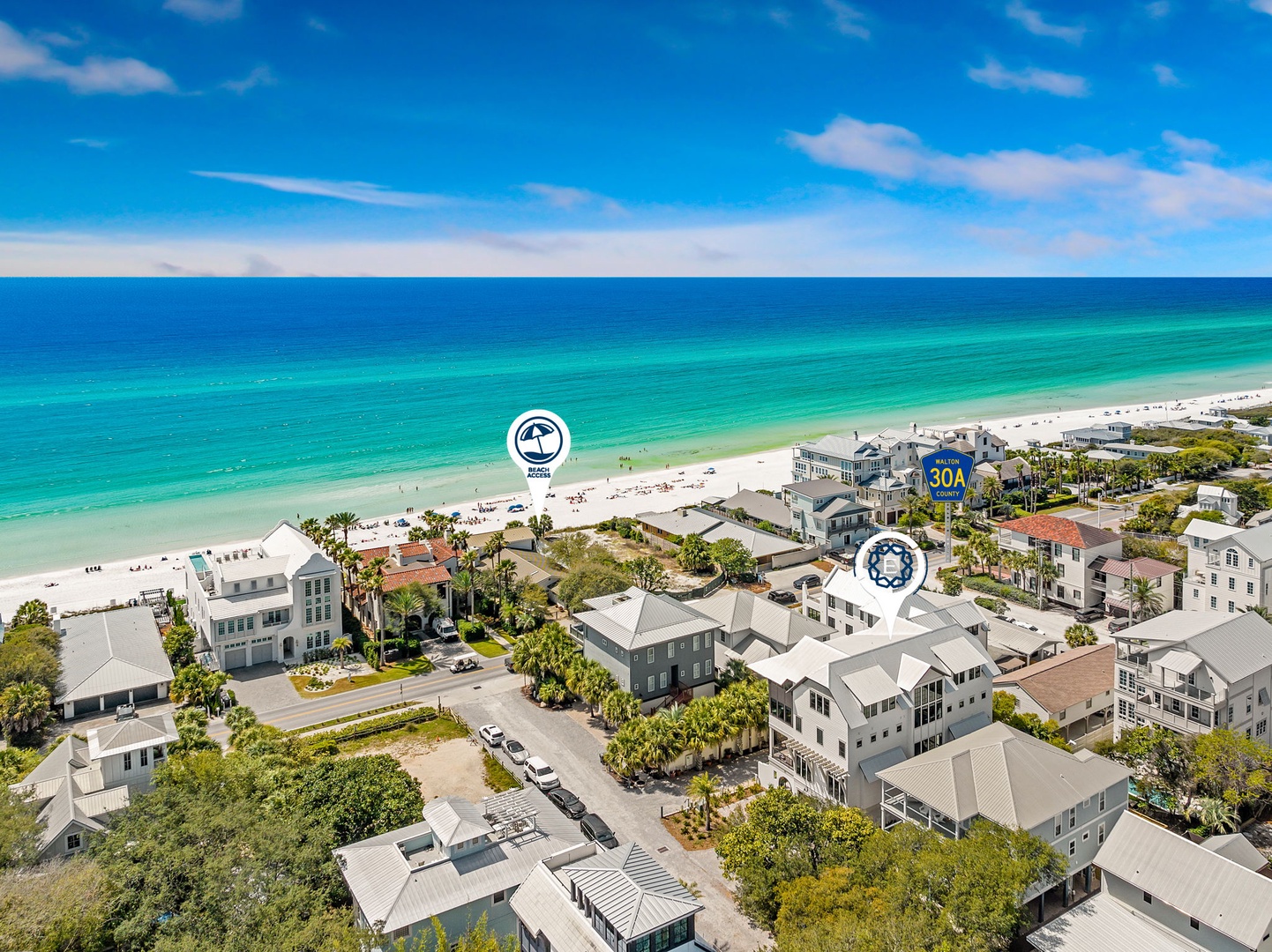 Aerial view of beachfront properties with pristine turquoise waters and white sand beach stretching along the coastline.