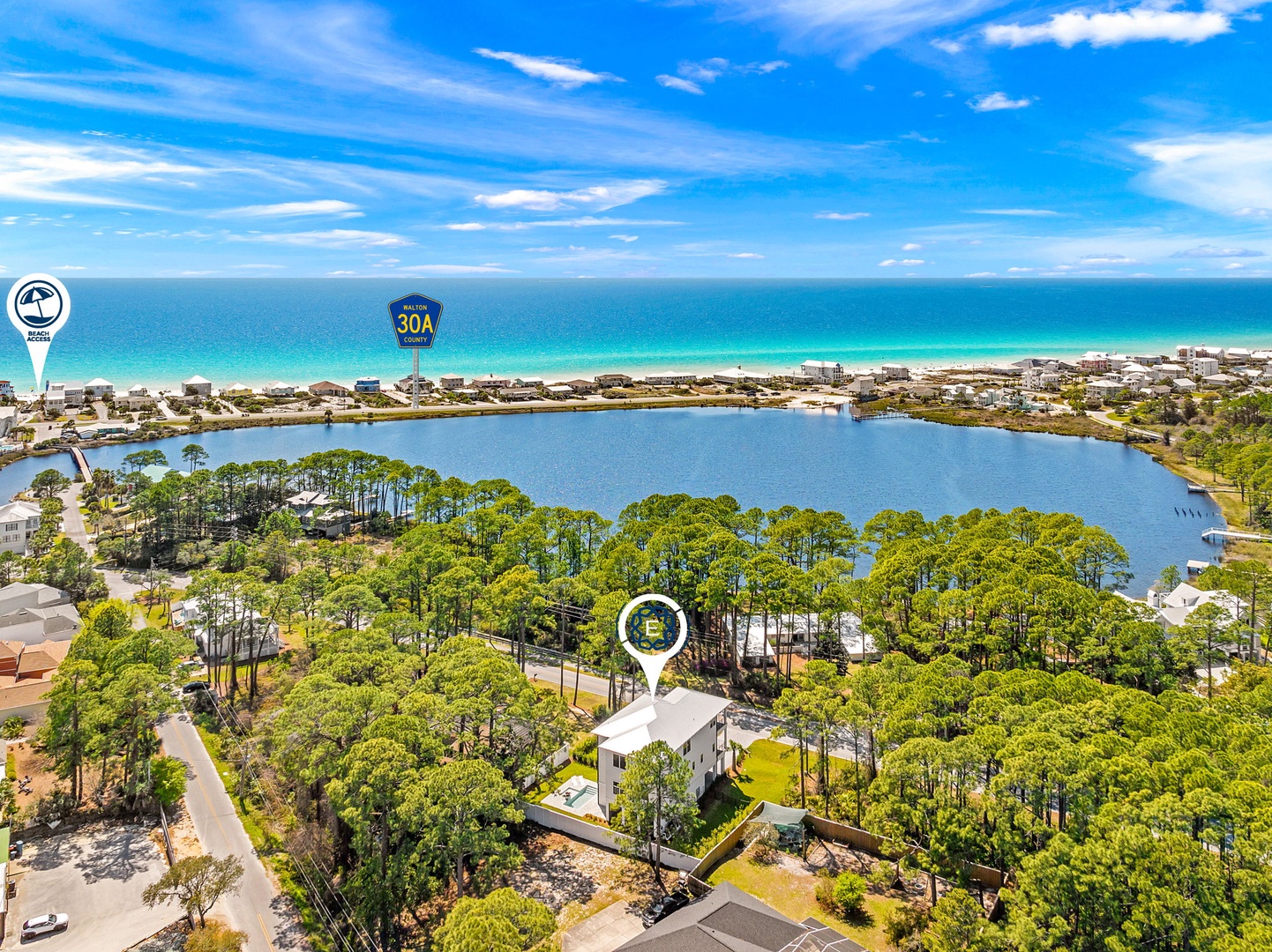 Aerial view showcasing the property's prime location between a serene lake and pristine beach along scenic Highway 30A.