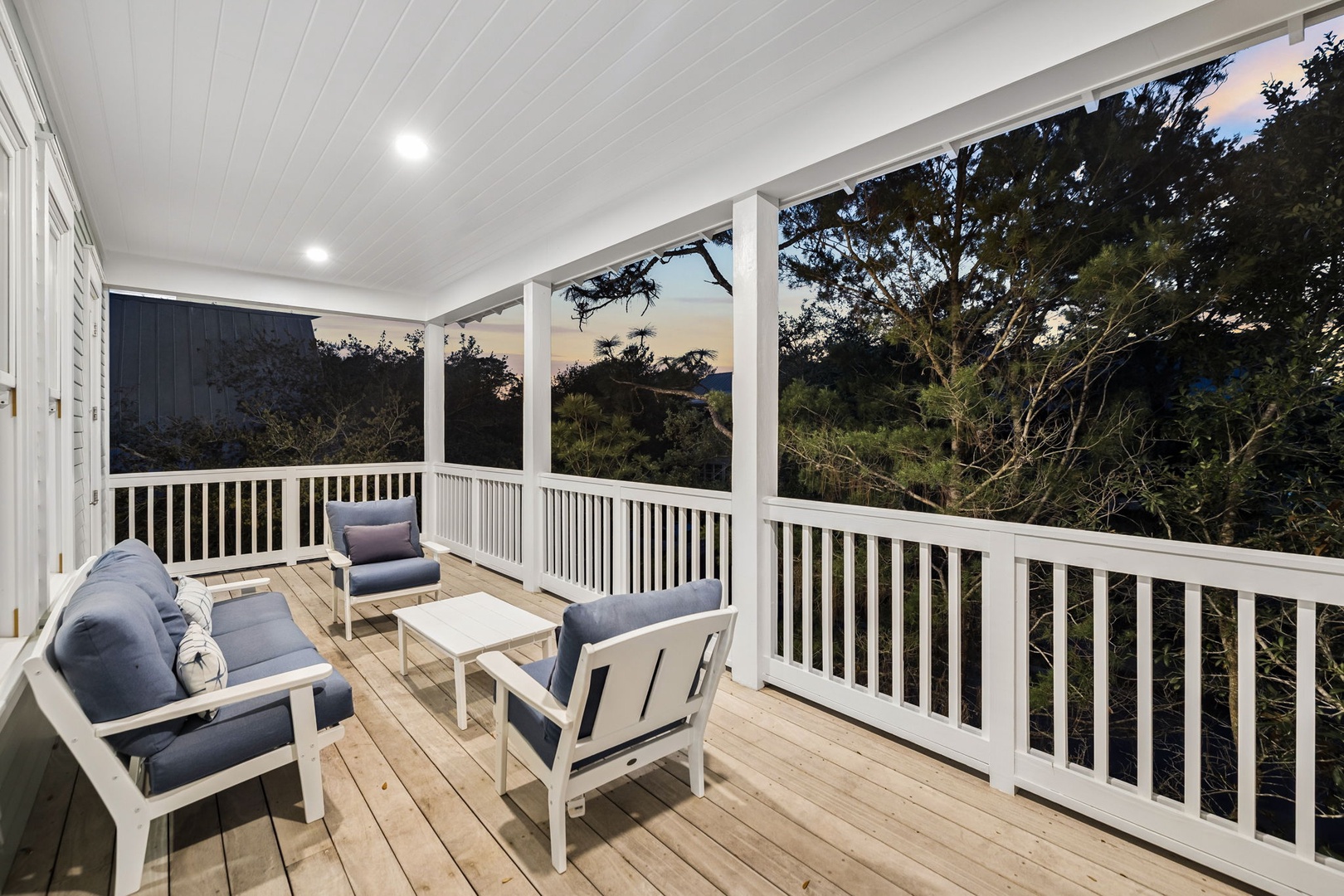 Unwind on your private covered terrace with comfortable outdoor seating overlooking lush treetops and peaceful mountain views.