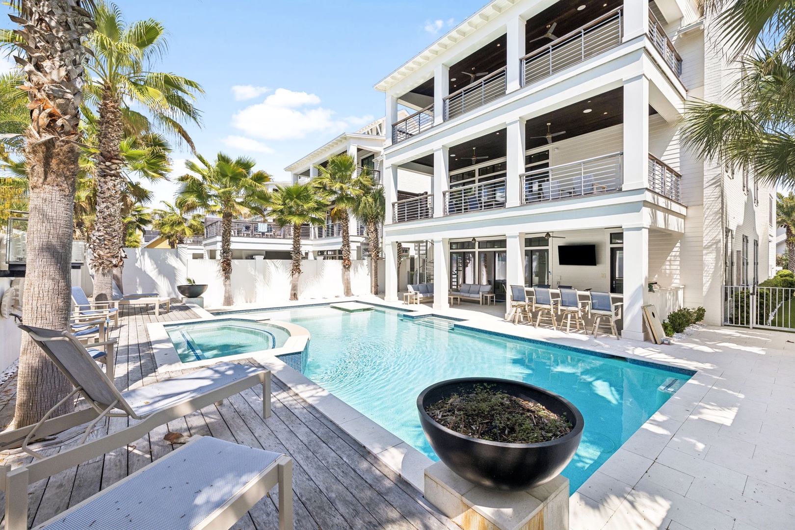 Your private oasis awaits with crystal-clear pool, luxurious hot tub, and tropical palms creating the perfect backdrop for relaxation.