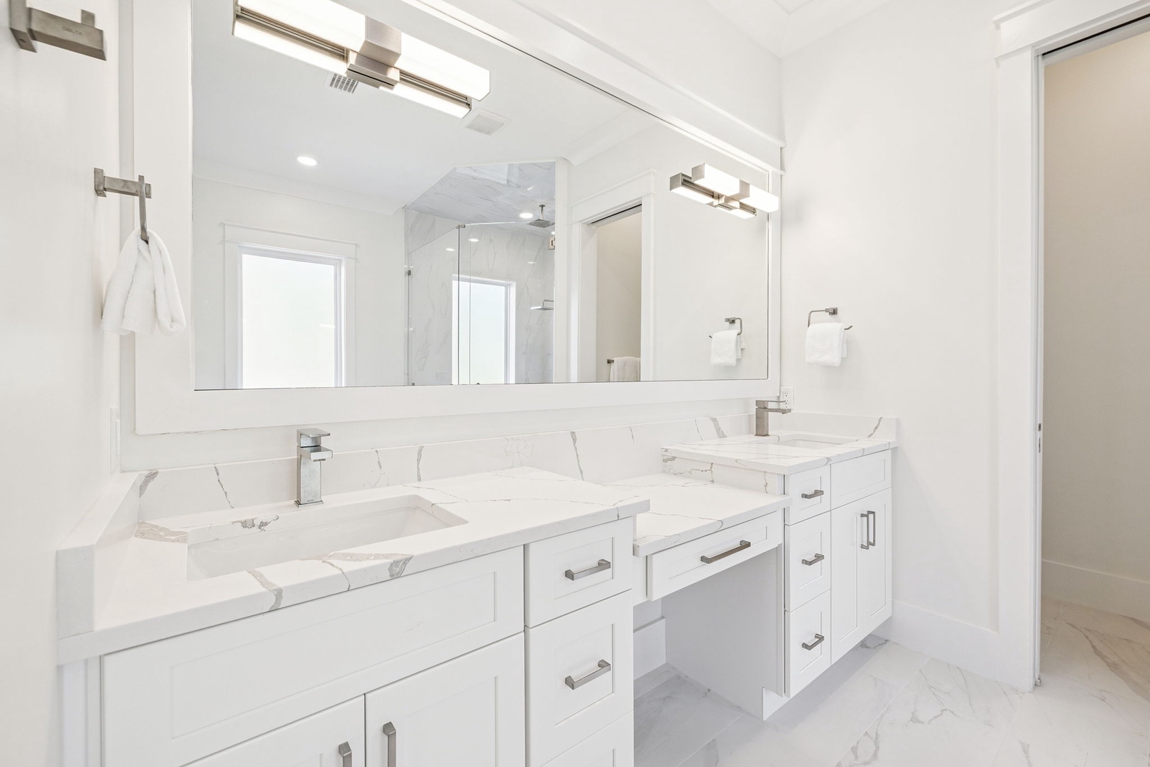 Unwind in this spa-like bathroom featuring dual vanities, marble countertops, and premium fixtures for your morning routine.