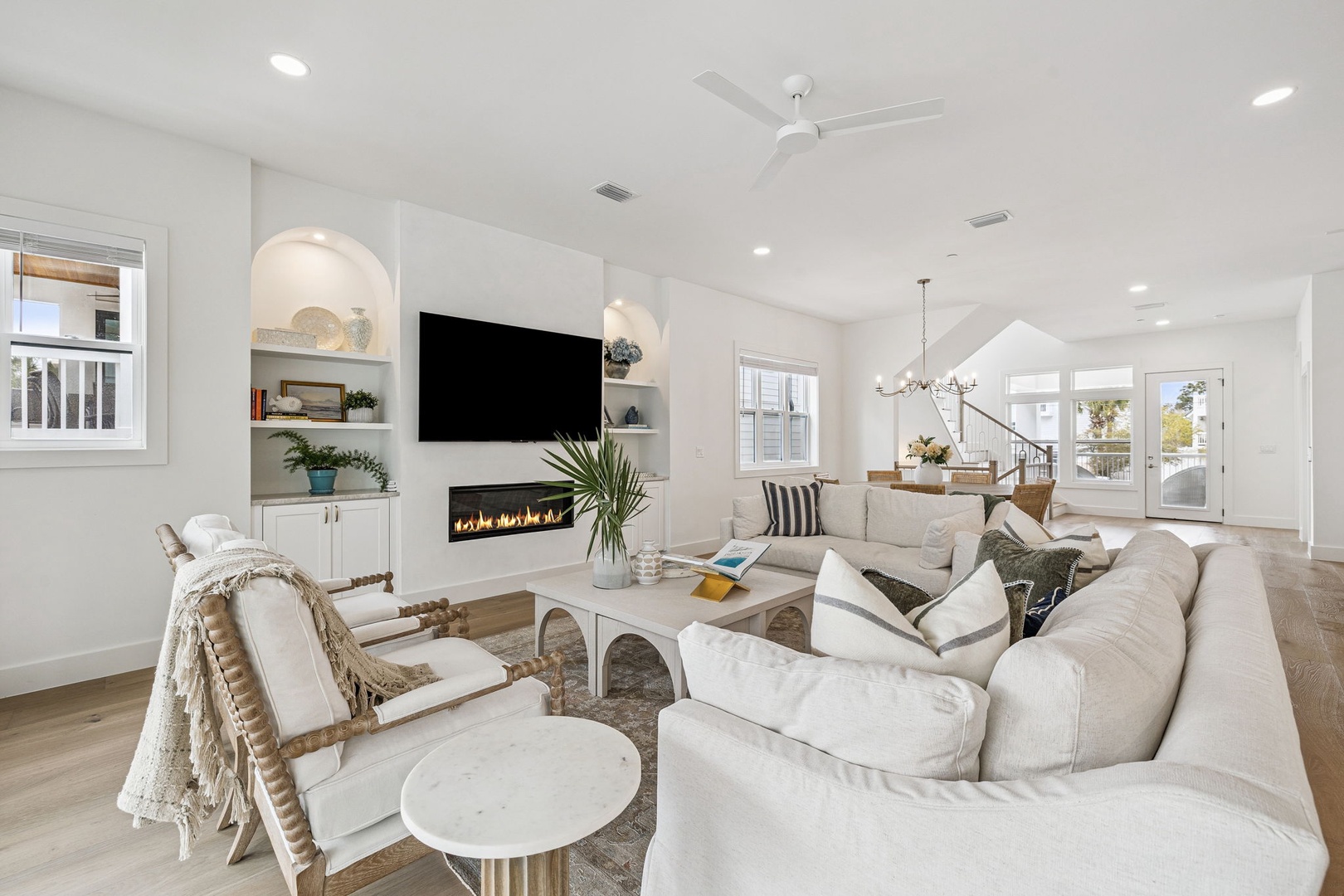 Sink into plush seating by your cozy fireplace, where modern elegance meets comfort in this bright, airy living space.