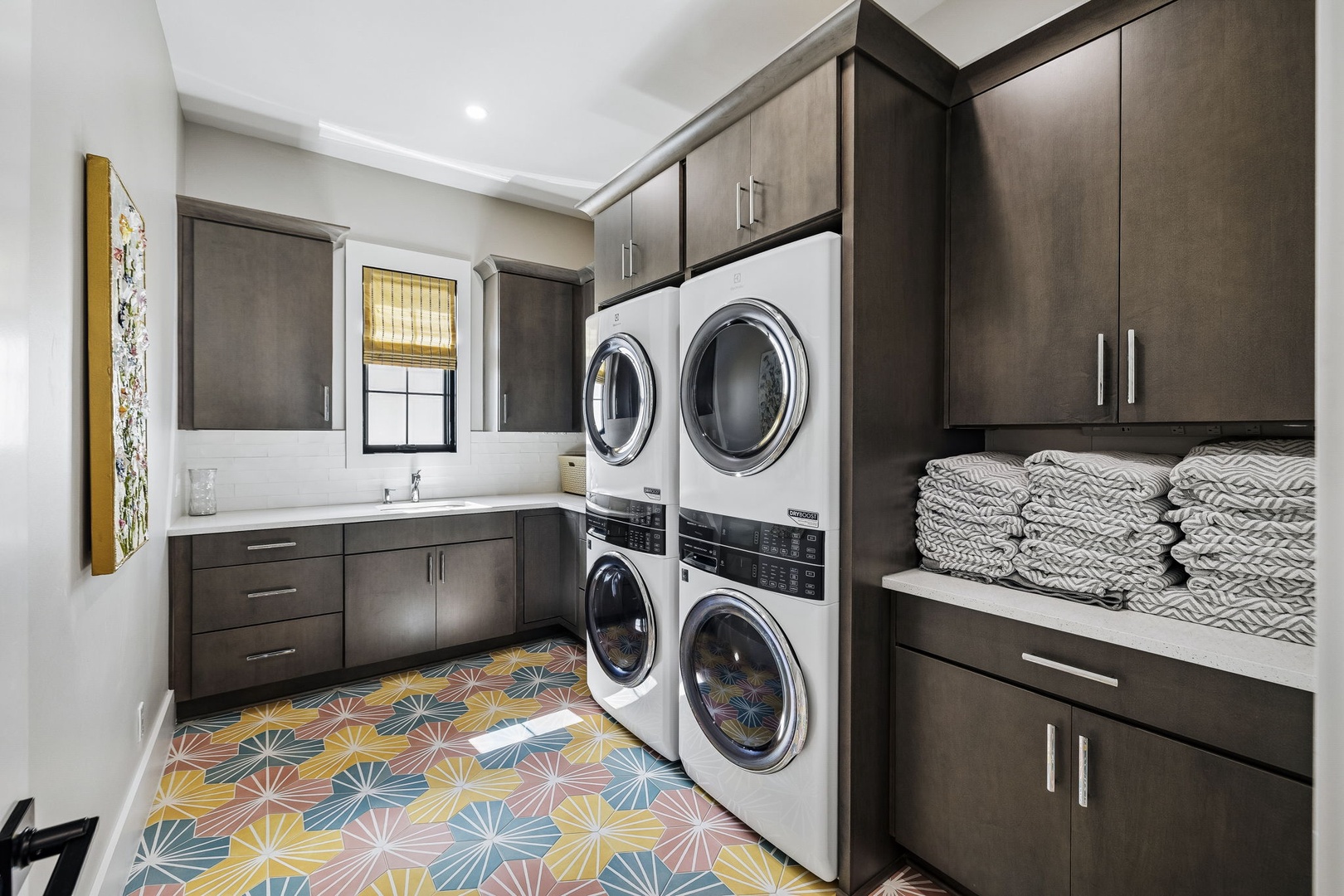 Your laundry room features a sleek, stylish design with modern stacked washers and dryers, plenty of cabinet storage, and fresh towels ready for your stay. Bright and functional, it makes keeping up with laundry effortless.