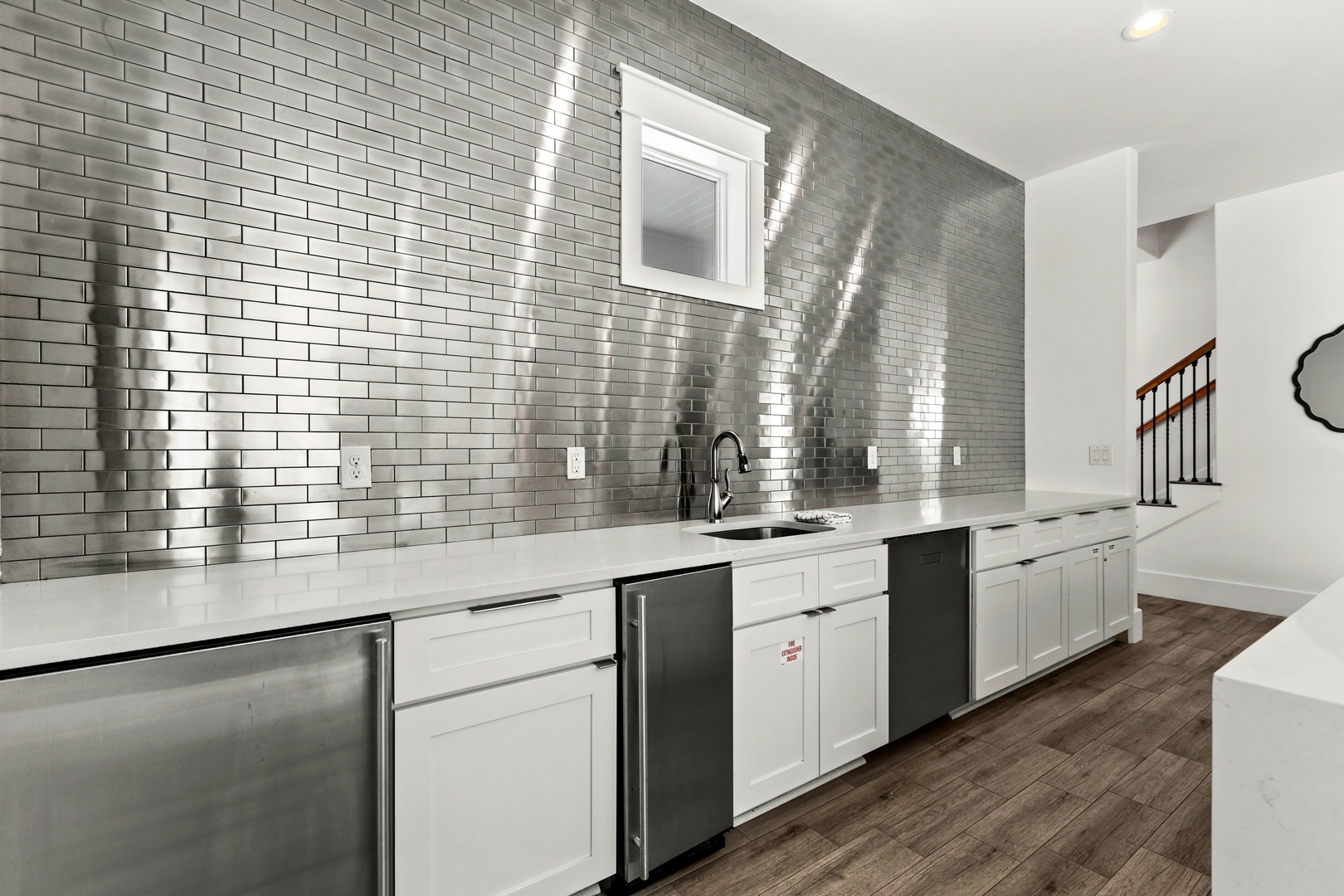 Gleaming subway tile and sleek appliances create your perfect backdrop for home-cooked meals or morning coffee. Light dances across the surfaces, making the space feel bright and inspiring.