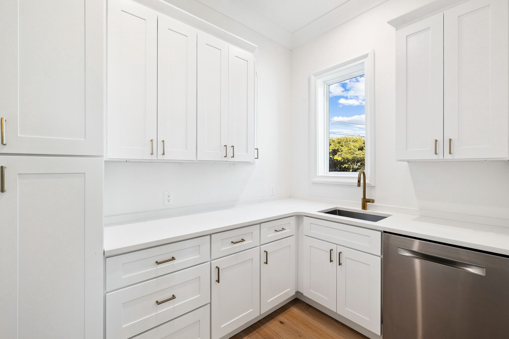 Your pristine white kitchen offers marble countertops, stainless appliances, and a bright window view for inspiring your culinary adventures.
