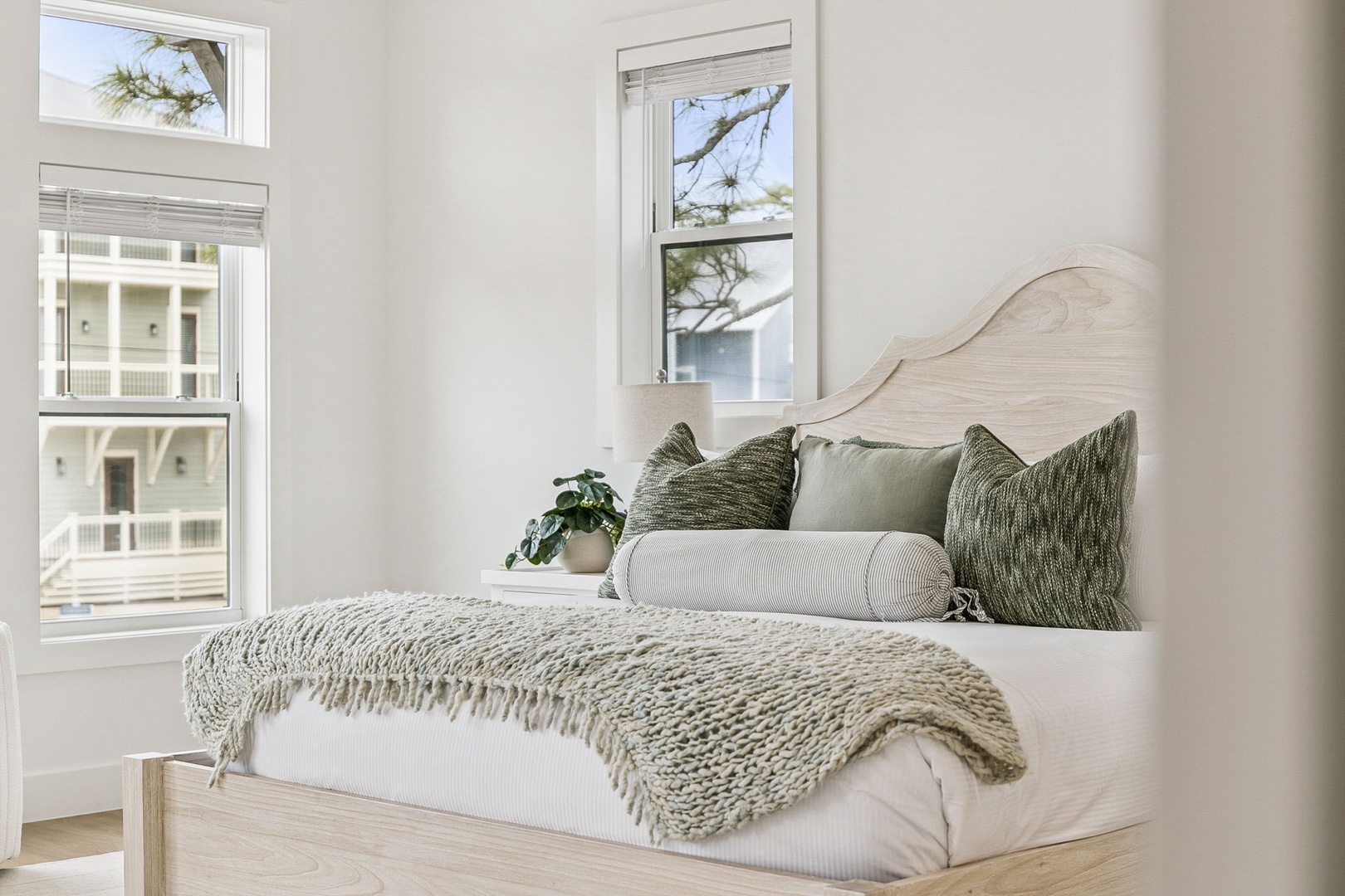 Your peaceful bedroom sanctuary features soft textures and natural light streaming through windows overlooking the quiet neighborhood streets.