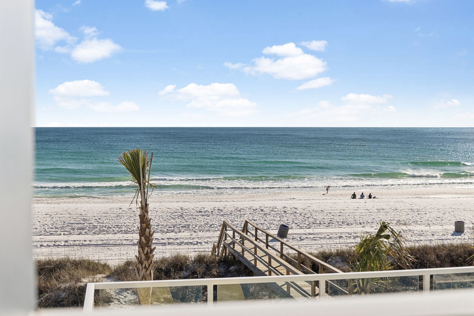 Beautiful oceanfront view with direct beach access from the property balcony, featuring pristine white sand and clear blue waters.