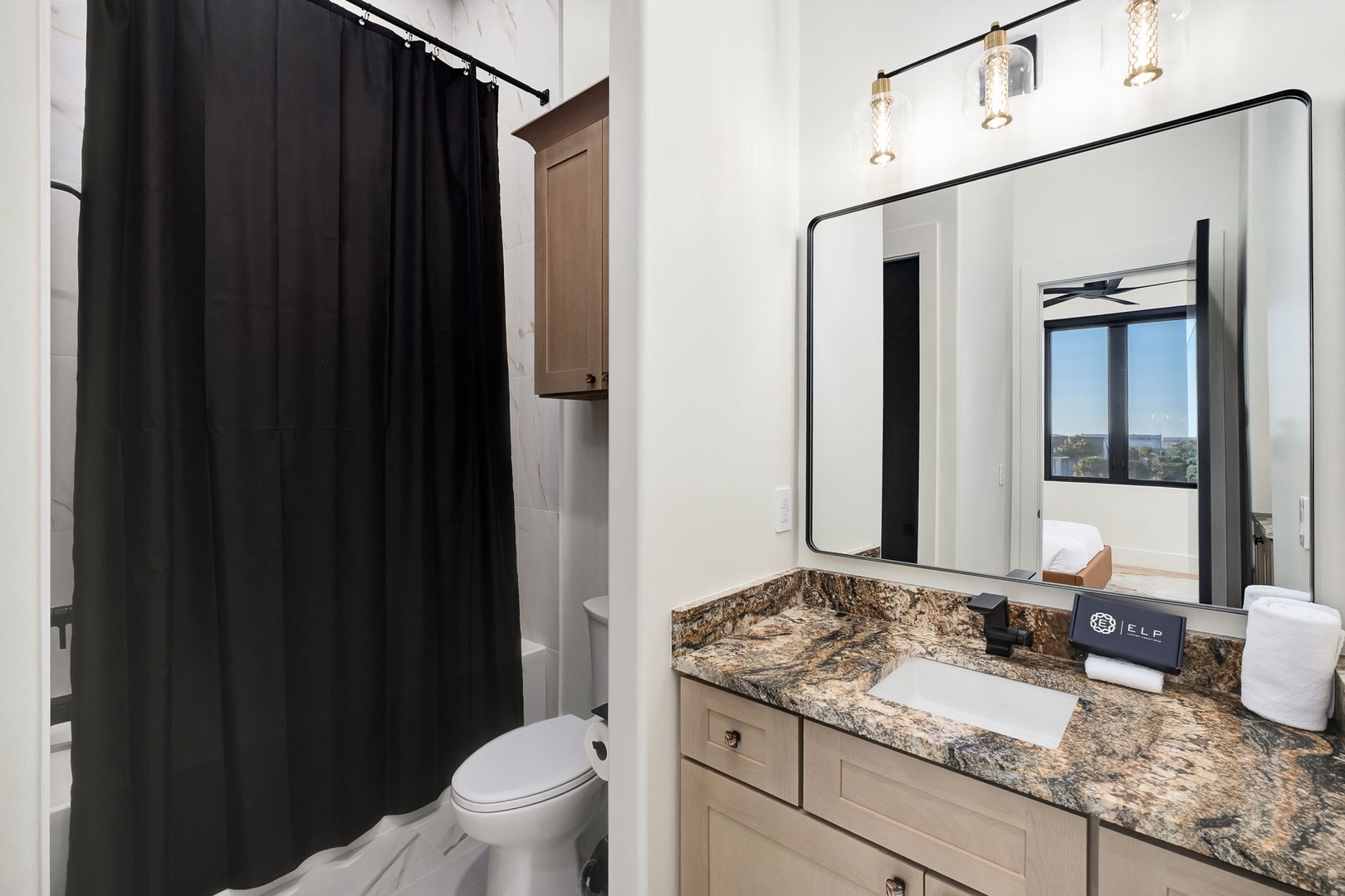 Refresh in your beautifully appointed bathroom featuring granite countertops, modern lighting, and a comfortable shower-tub combo.