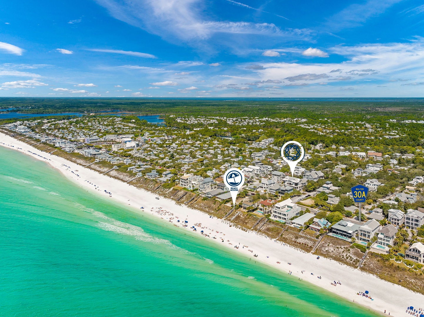 Stunning aerial view of pristine white sand beach meeting turquoise waters, with vacation rentals nestled among lush coastal vegetation.