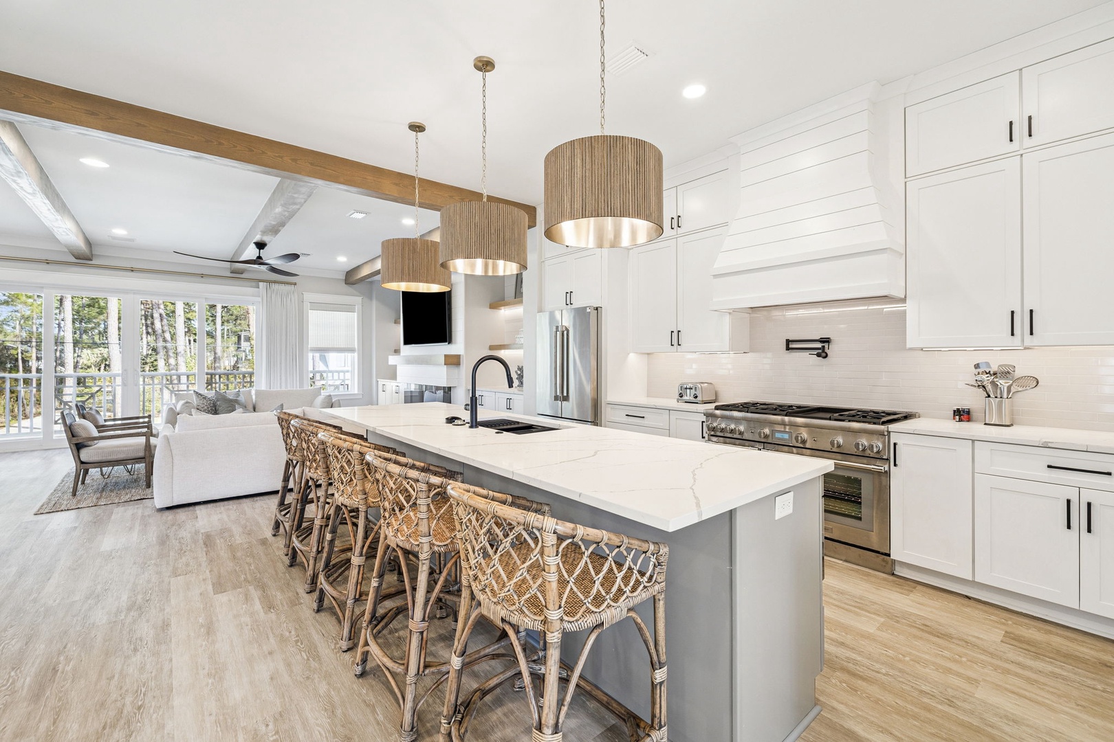Your gourmet kitchen beckons with a spacious island, premium appliances, and warm wicker seating perfect for morning coffee and evening meals together.