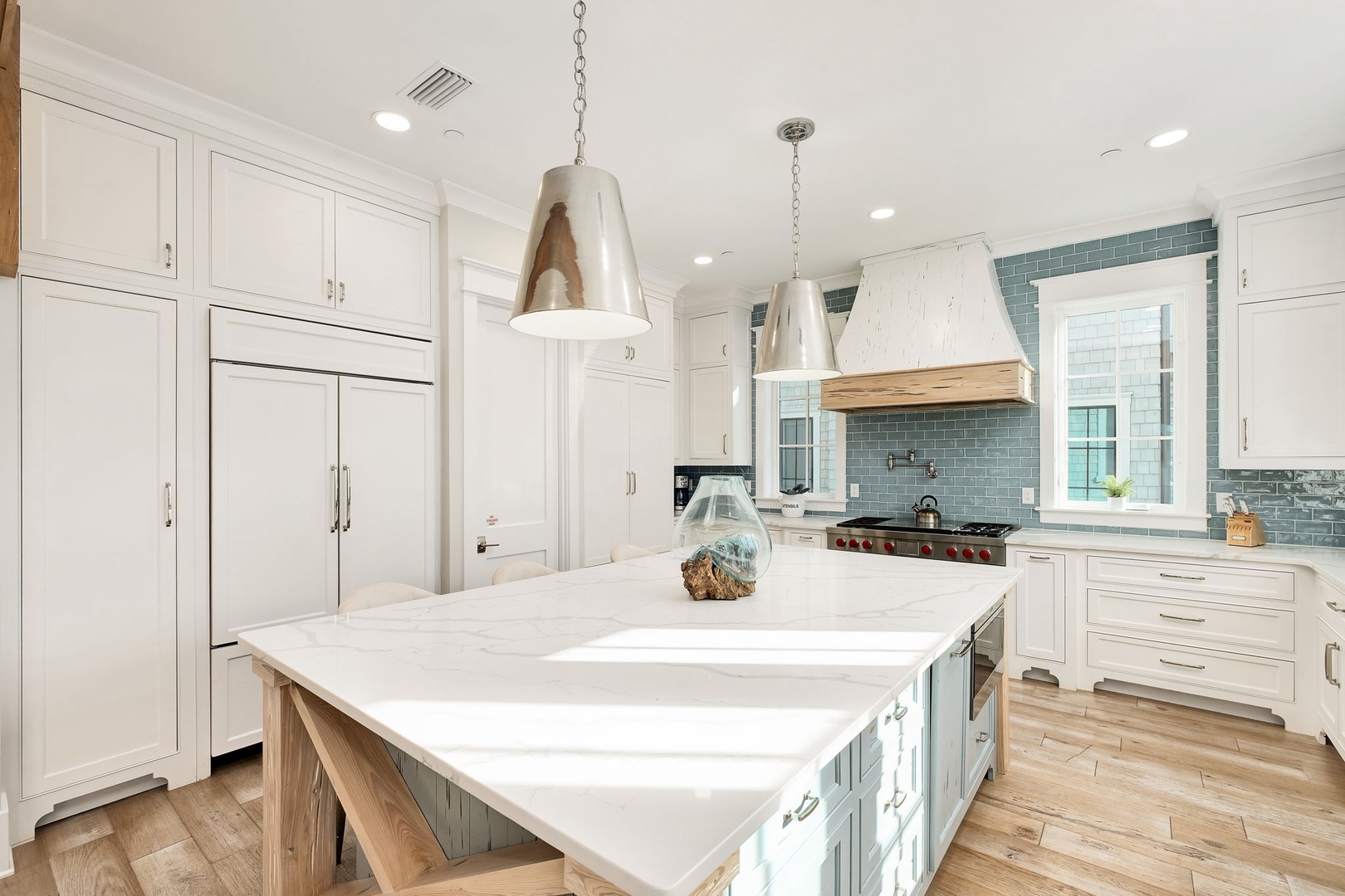 Your spacious gourmet kitchen awaits with marble countertops, professional-grade appliances, and coastal-inspired blue tiles perfect for creating memorable meals.