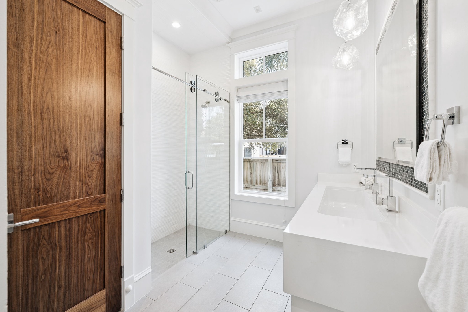 Unwind in your luxurious bathroom featuring a marble soaking tub, glass shower, and warm wood accents creating the perfect spa retreat.