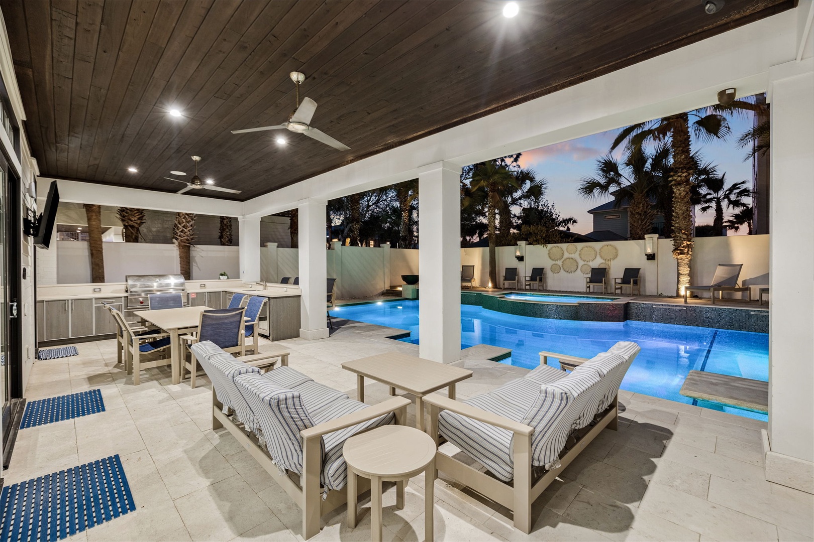 Unwind in your private outdoor kitchen where you'll cook and dine poolside as evening lights dance on the water.
