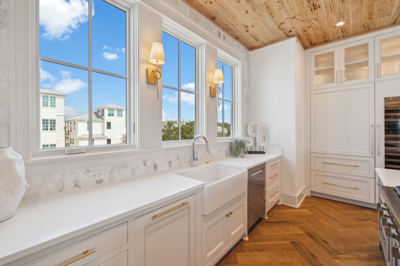 Cook your favorite meals in this sunlit kitchen with stunning wood ceilings, marble backsplash, and ample custom cabinetry—your home away from home awaits.