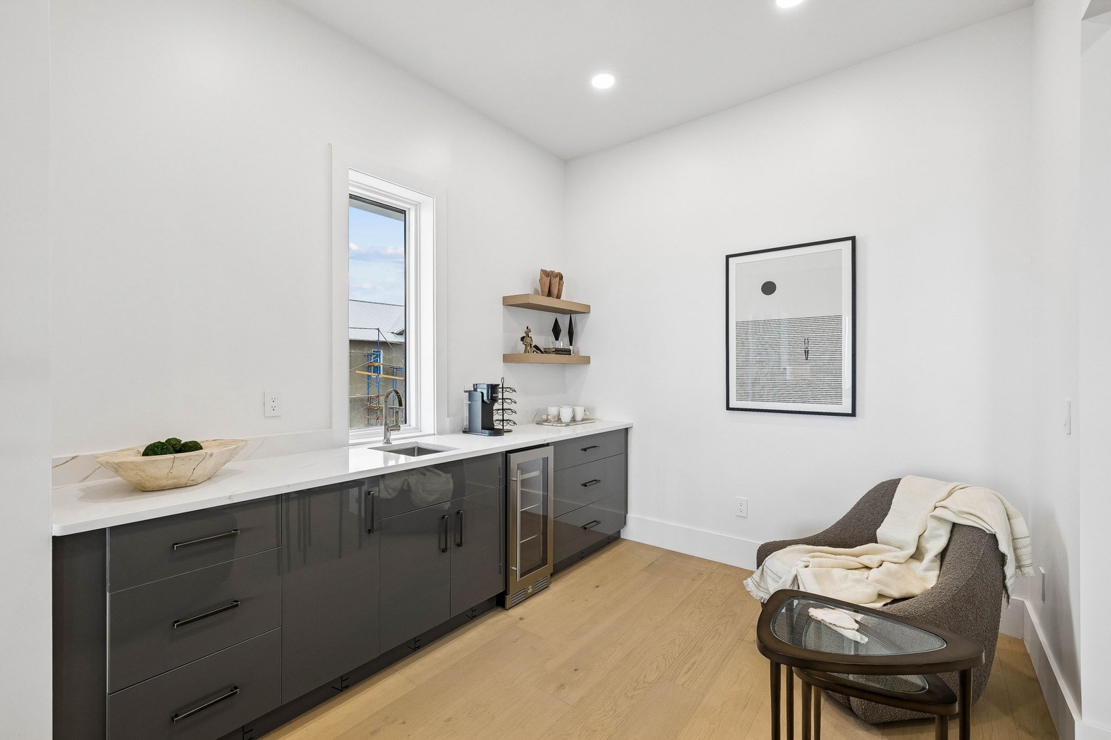 Settle in at your sleek wet bar, complete with a wine fridge and elegant marble countertops. The window brings in natural light, while the cozy reading nook invites you to unwind after a day of exploring.