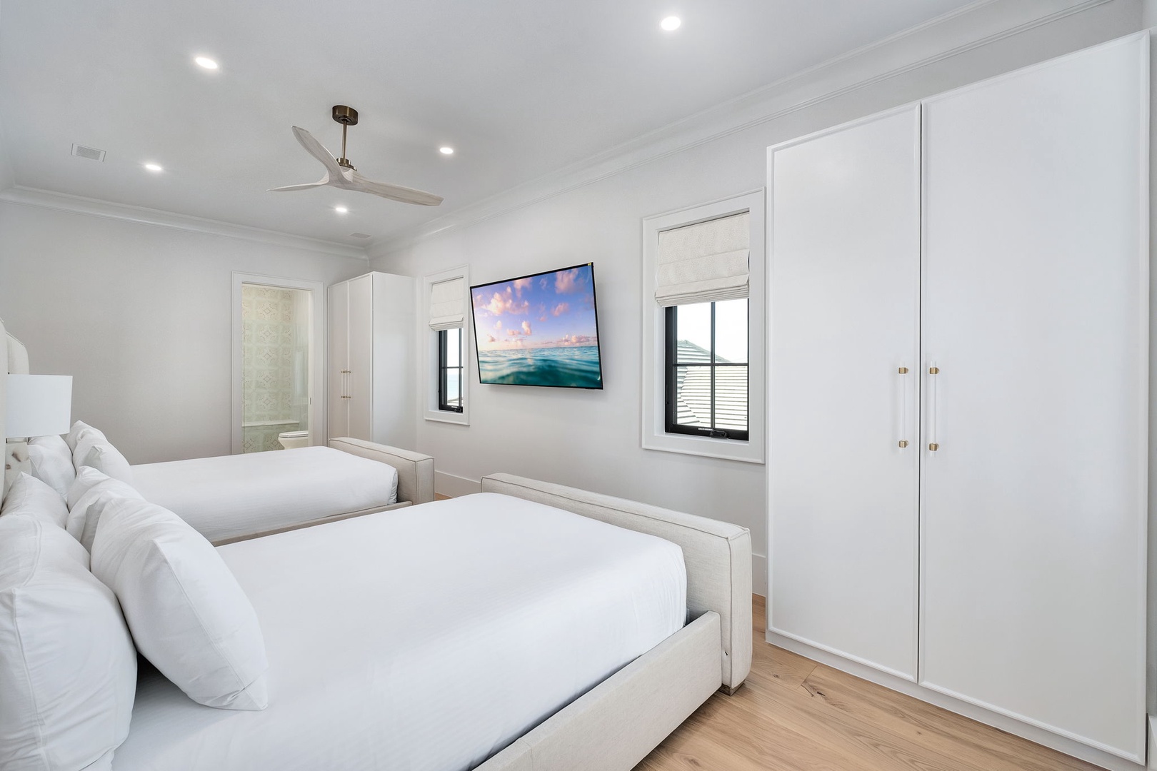 Drift off peacefully in your bright twin bedroom, where crisp white linens and a gentle ceiling fan ensure restful nights.