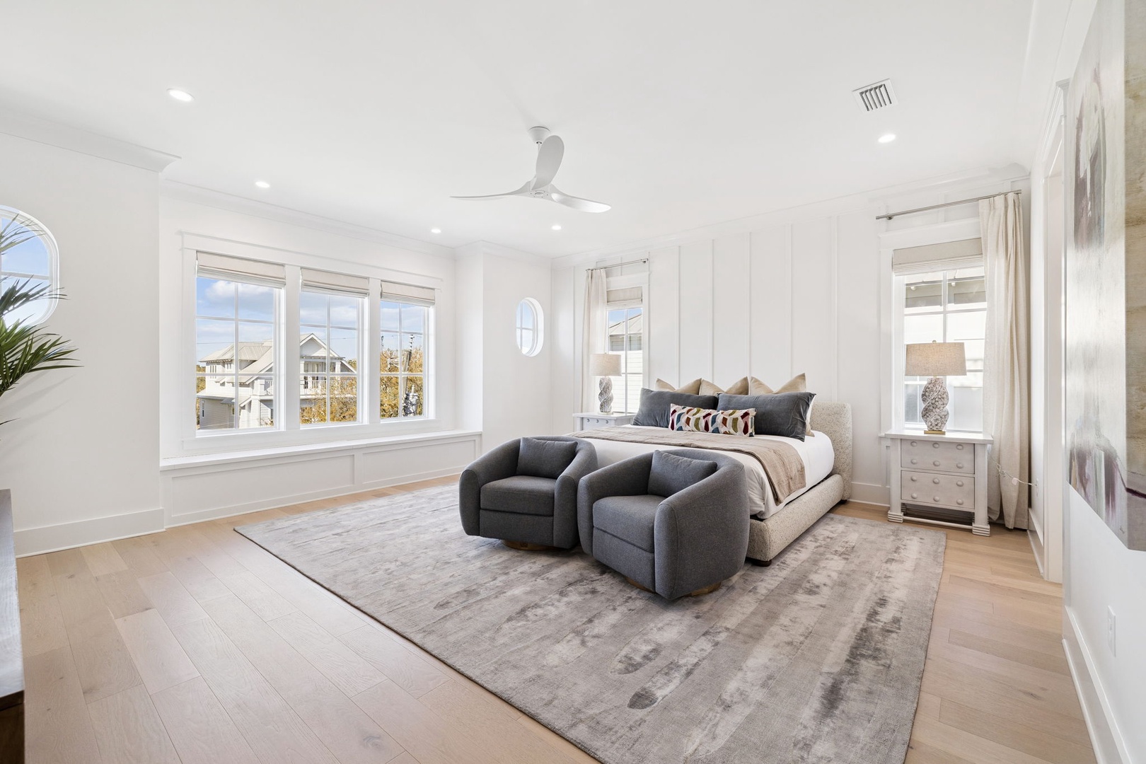 Sink into this elegant bedroom's plush seating area while natural light streams through oversized windows, creating your perfect retreat.
