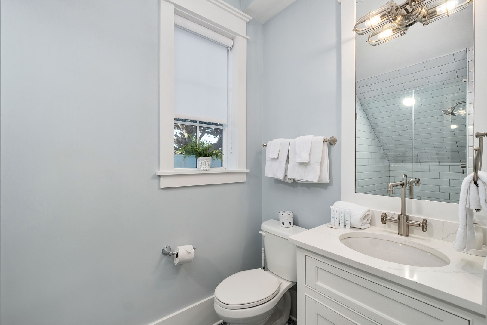 Step into your pristine bathroom where soft blue walls create a spa-like retreat. Fresh towels await your arrival.