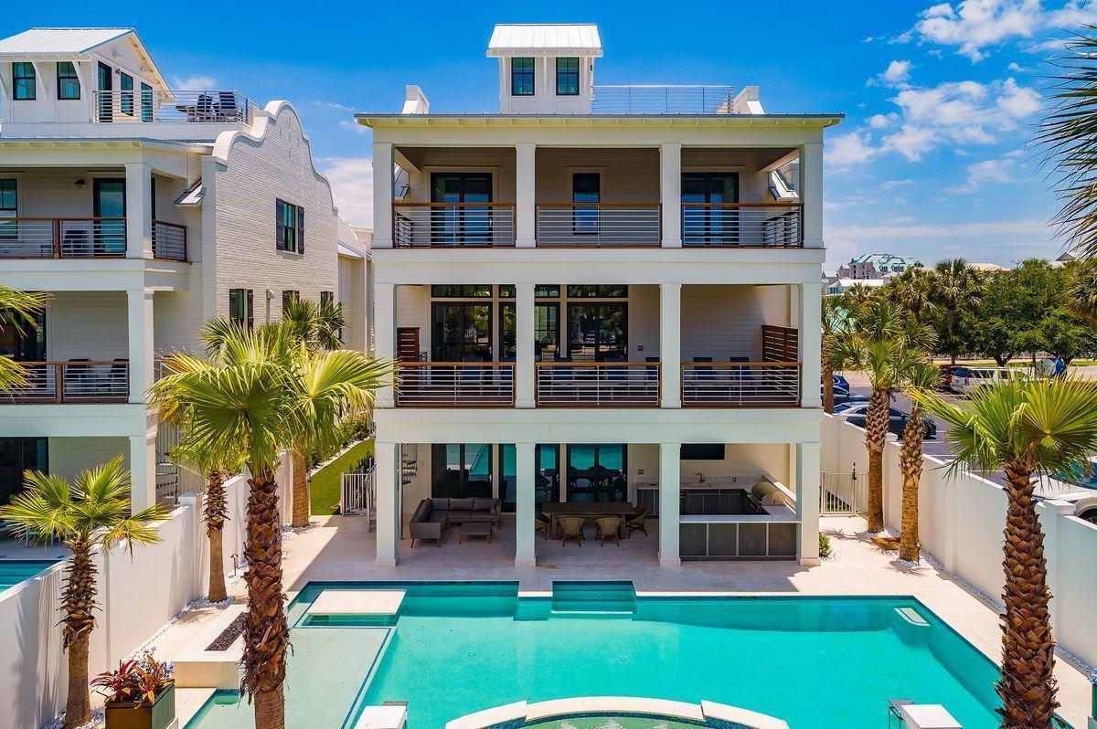 Modern luxury villa with pristine pool and tropical landscaping in an upscale coastal community.