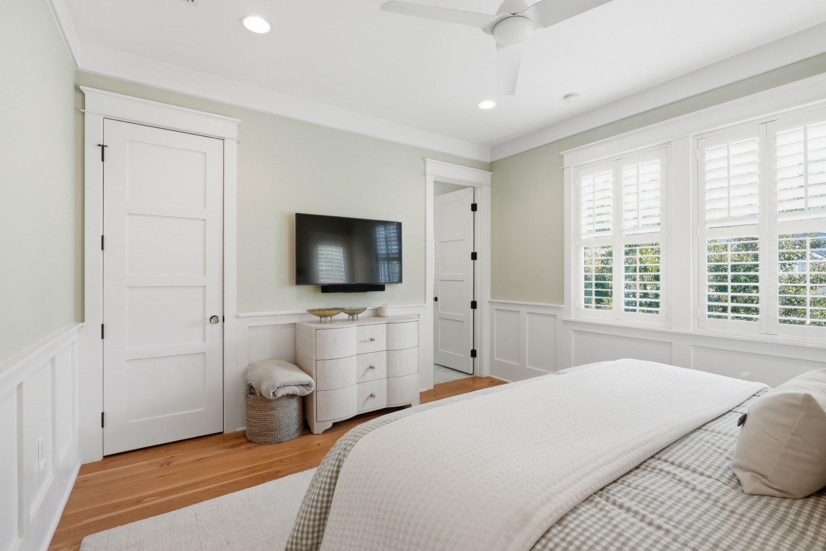 Sink into crisp linens in your bright, airy bedroom, where plantation shutters frame garden views and thoughtful details create a serene retreat for restful nights.