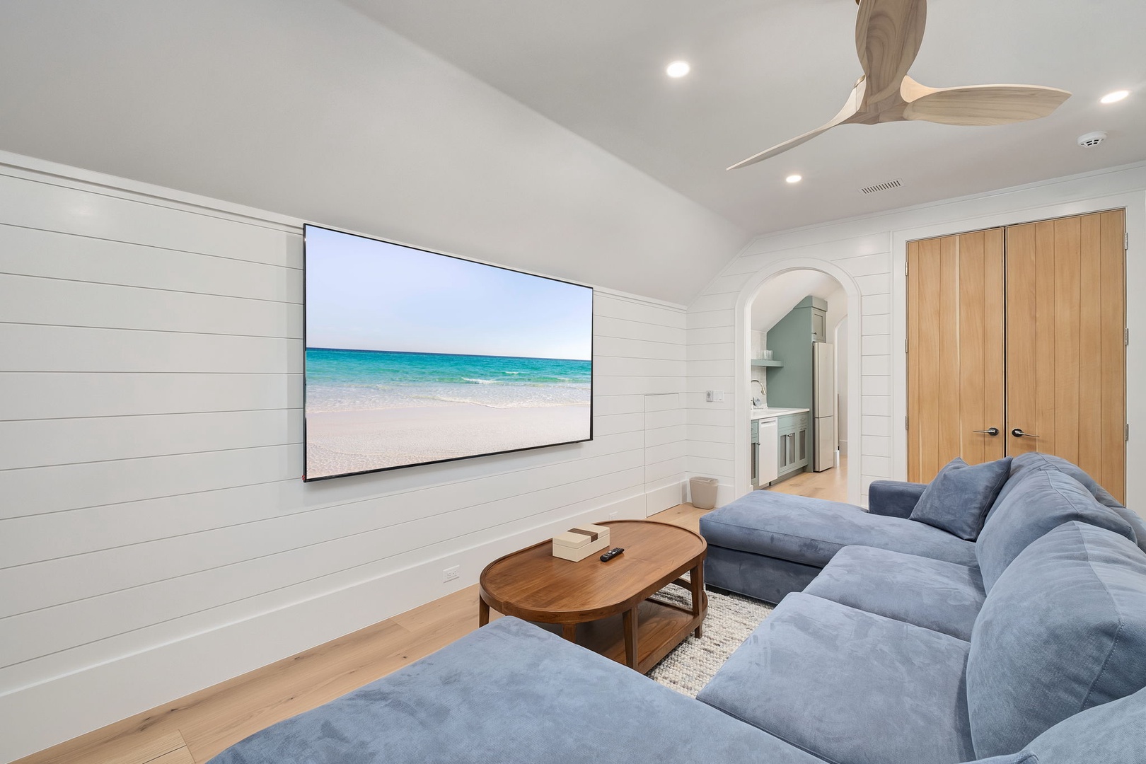 Sink into plush blue sofas and enjoy movie nights on your large wall-mounted TV in this beautifully designed living space.
