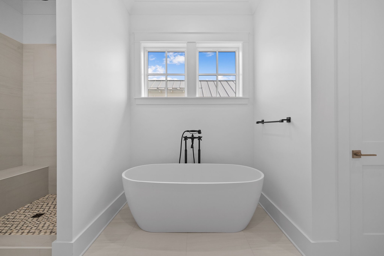 Unwind in your luxurious soaking tub with calming natural light streaming through the window, creating a perfect spa-like retreat.