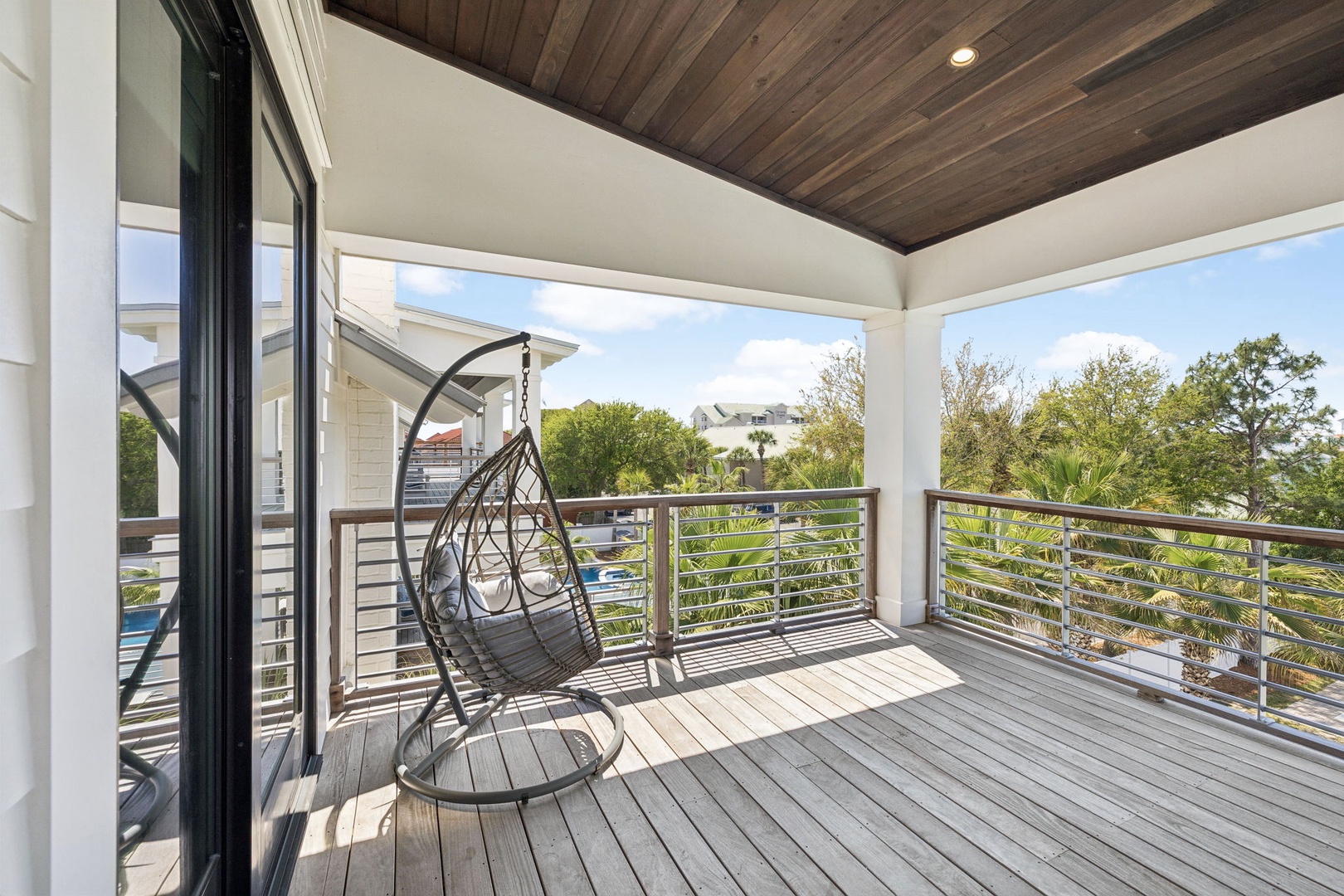 Sway gently in your private hanging chair on this beautiful covered deck with lush treetop views.