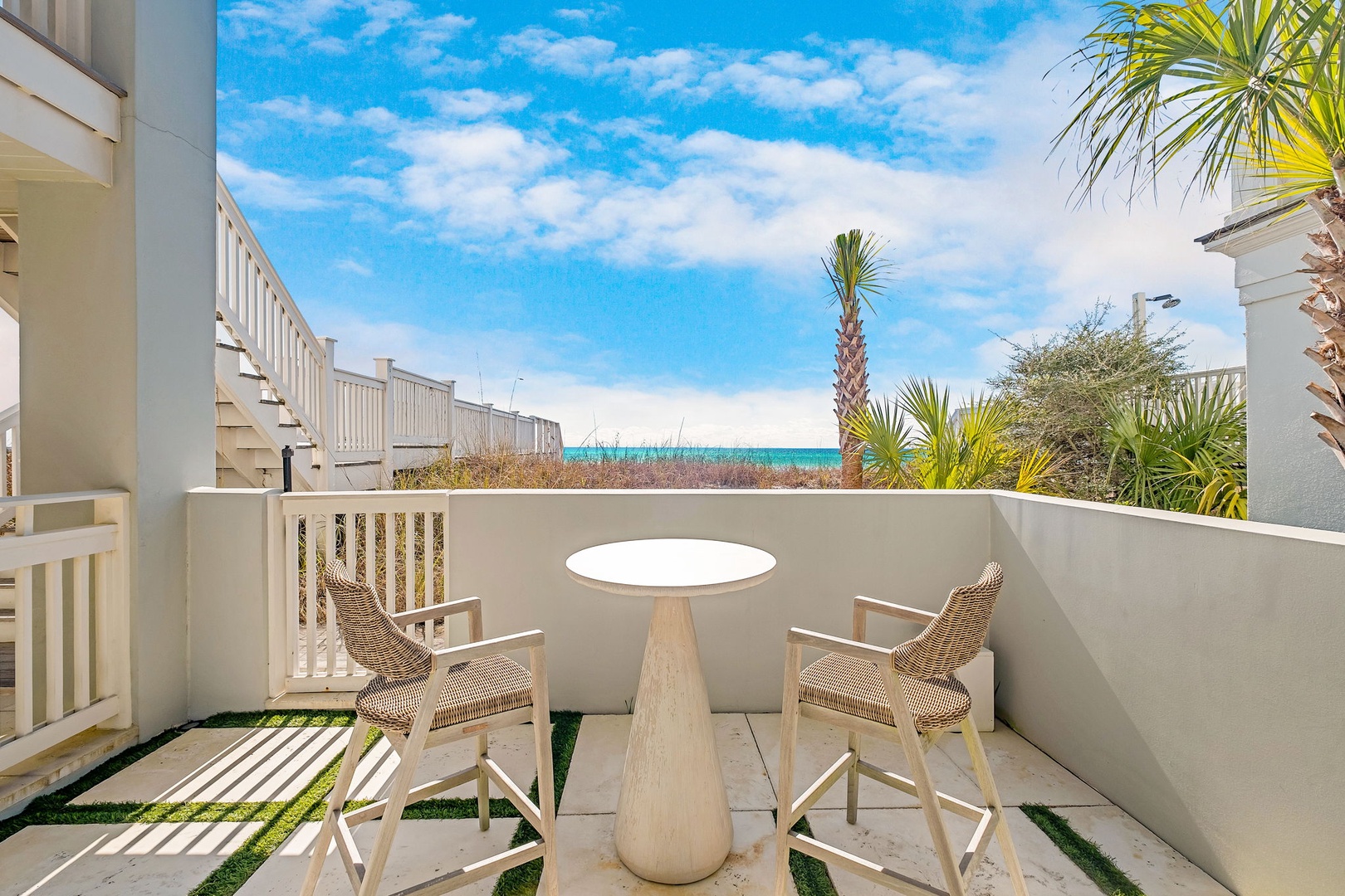 Sip your morning coffee at this charming coastal patio, where turquoise waters meet blue skies just beyond swaying palms. Your private outdoor escape awaits.