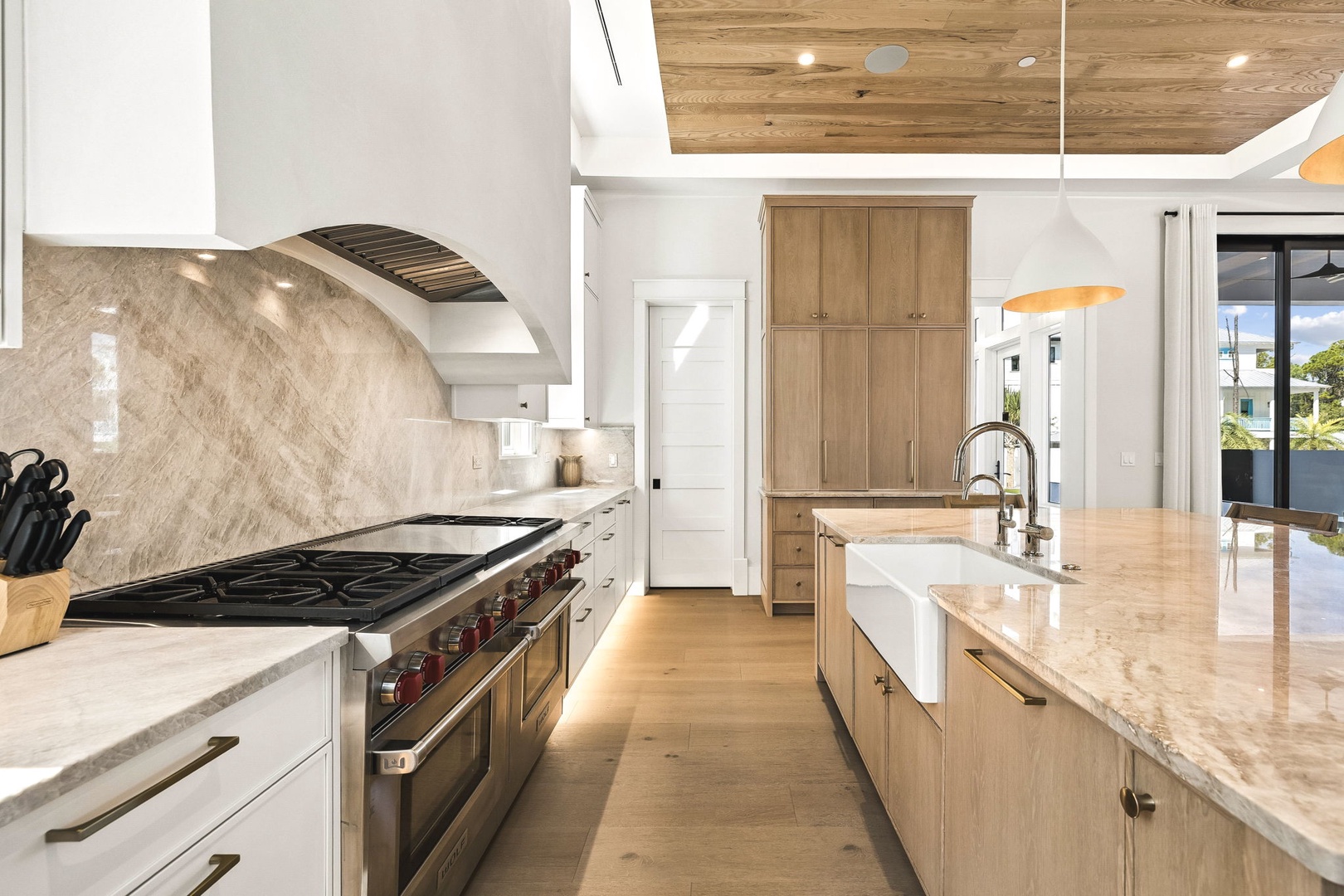 Picture yourself preparing meals in this stunning gourmet kitchen, where natural wood tones and marble surfaces create your perfect culinary retreat.
