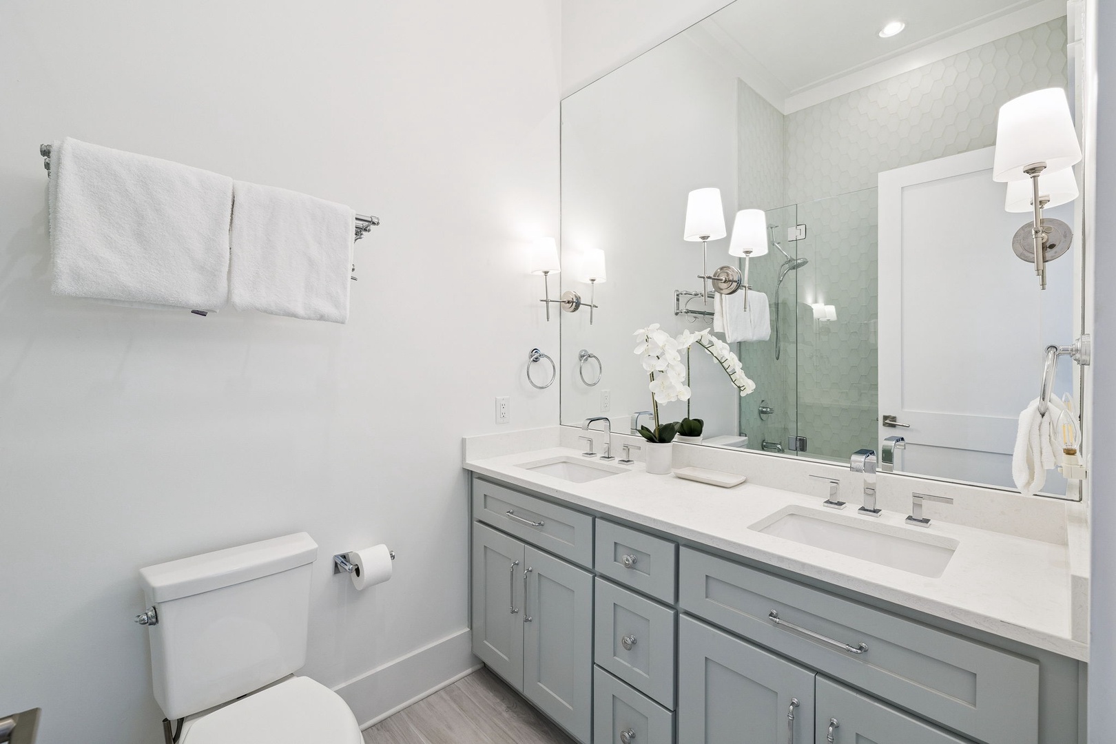 Unwind in this elegant bathroom featuring marble counters, dual sinks, and fluffy towels awaiting your relaxing morning routine.