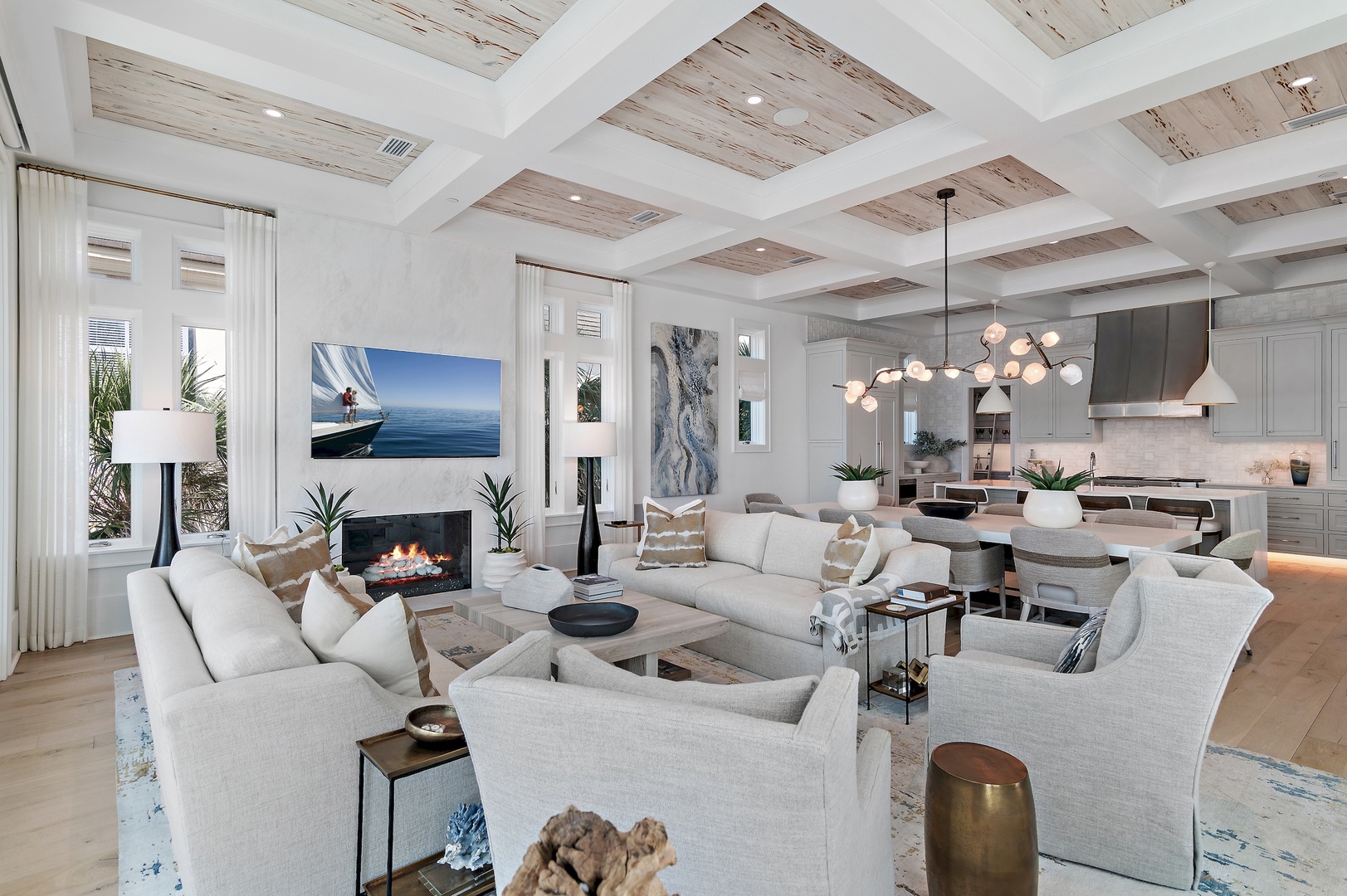 Sink into plush seating beneath the stunning coffered ceiling where your open living and dining spaces flow seamlessly together. The cozy fireplace sets the perfect ambiance for your coastal retreat.