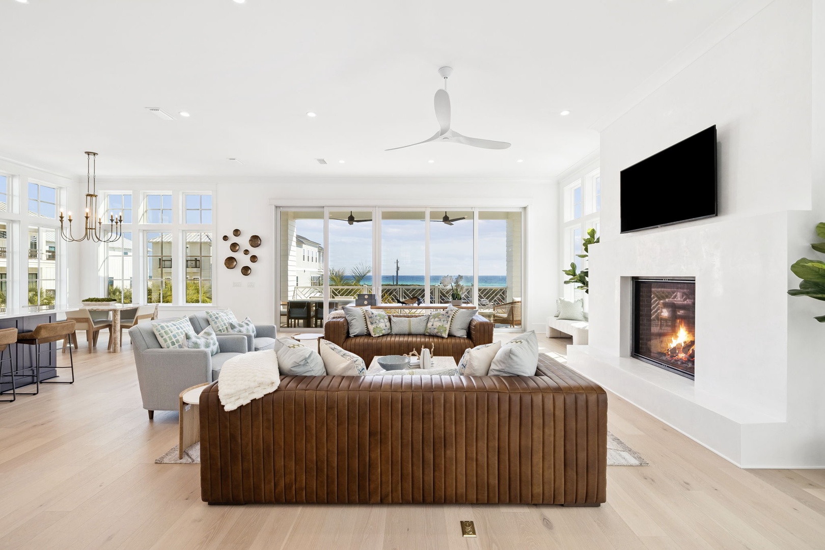Unwind in this stunning open-concept living space where modern elegance meets coastal charm, complete with fireplace and ocean glimpses.