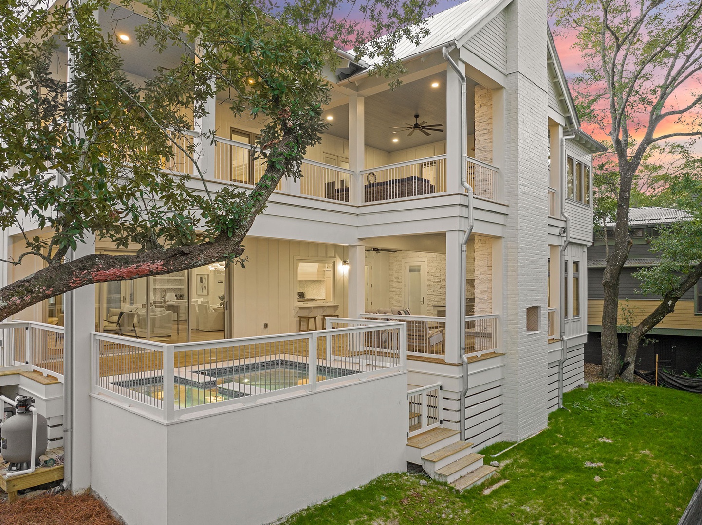 Modern multi-level home featuring clean architectural lines and warm evening lighting in a tree-lined neighborhood setting.