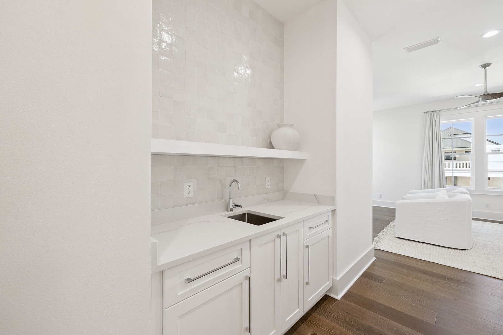 Your pristine white kitchen features gleaming countertops and modern appliances, perfect for preparing meals during your stay.