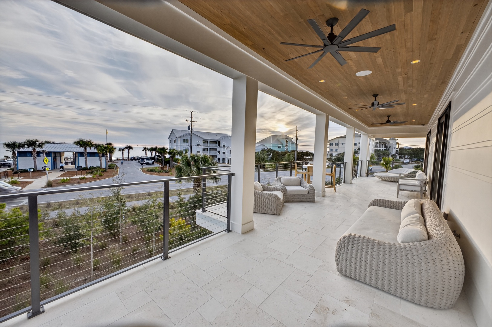 Relax on this expansive covered terrace with comfortable seating while taking in the coastal neighborhood views.