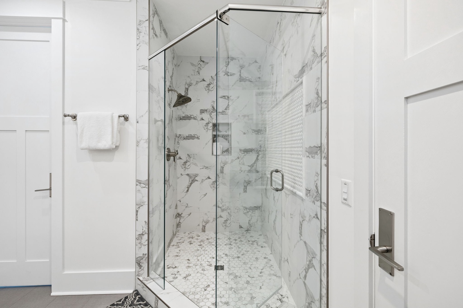 Step into your spa-like shower sanctuary with stunning marble walls and rainfall showerhead for pure relaxation.