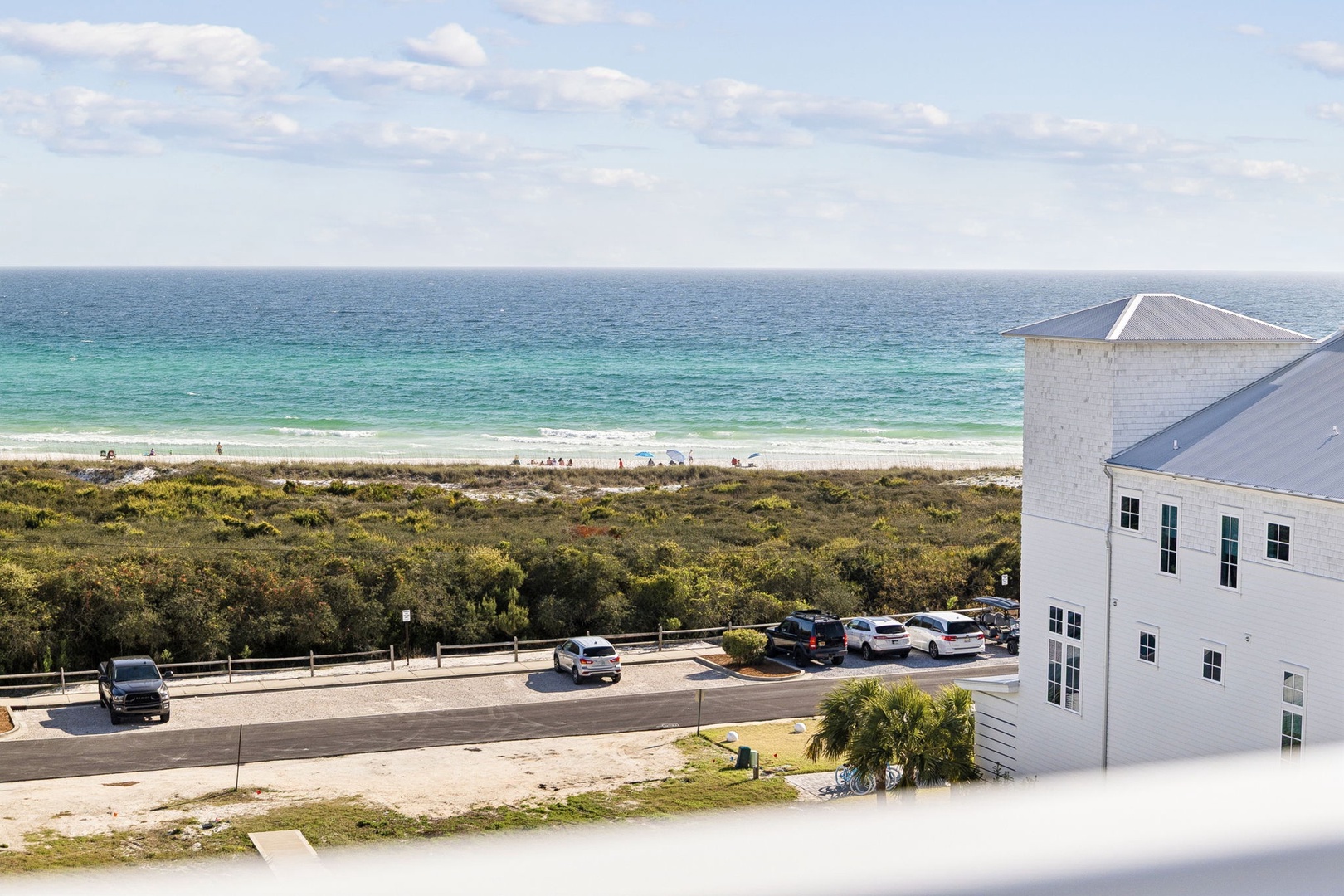 Stunning beachfront view showcasing pristine white sand, turquoise waters, and convenient parking just steps from the shore.